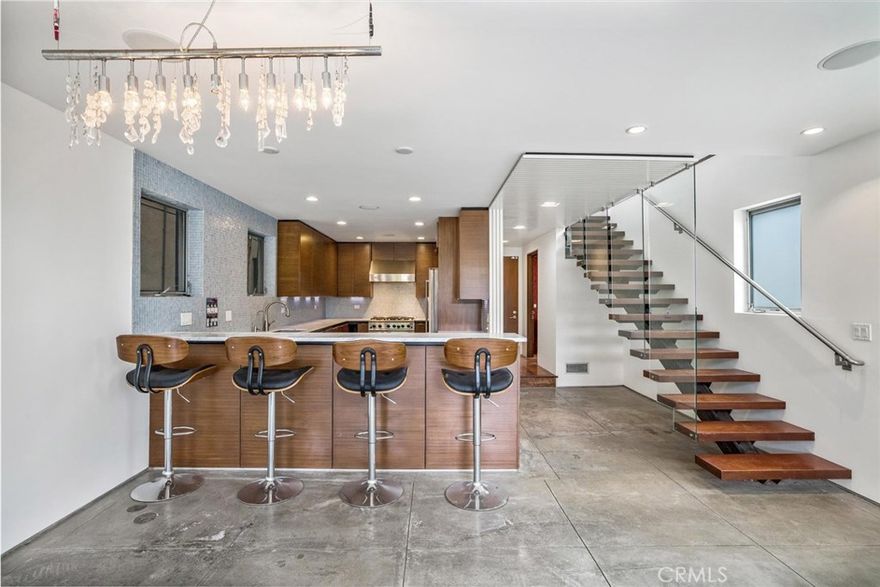 Chic and Sophisticated this Modern Architectural 4 bed 3 bath home with an incredible roof top deck is perfect for entertaining and enjoying the Venice lifestyle. Warm and inviting, the light filled living room with floor to ceiling windows, fireplace with the artistic touch of a D. Zapata original, concrete flooring and steel accents opens to the Chef's kitchen equipped with custom mahogany cabinetry, Carrera counter tops, glass mosaic back splash and high end stainless steel appliances. The floating wood & glass staircase leads you to the second floor with two sizable bedrooms, designer bath, laundry room and an artistic space overlooking the living room perfect for a study or reading lounge. The third floor boasts a generous master bedroom complete with its own private bath and decorative touches and a 4th bedroom and a media room. The roof top deck with its' 360 degree city & mountain views adds to the unmistakable ambiance of Venice. Two car attached garage. Close to Abbot Kinney & the beach!