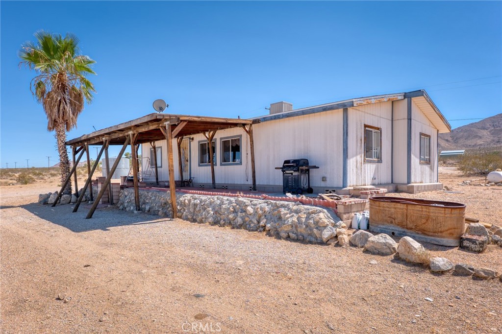 Discover wide-open desert living in this 3-bedroom, 2-bath manufactured home on 5 sprawling acres in Johnson Valley. Just a couple of lots from BLM land and the Big Horn Mountain Wilderness Area, this property offers direct access to endless trails, off-roading, and the natural beauty that makes the High Desert so unique. From the home, take in sweeping views of the vast desert landscape, surrounding mountains, and even up toward Big Bear.
Inside, vaulted ceilings and abundant natural light create an open and inviting feel. The living room is carpeted and flows into the dining area, which sits just off the galley-style kitchen. The kitchen features a gas stove and a window over the sink that frames the desert scenery. A laundry area with washer/dryer hookups provides convenient access to the back patio.
The primary suite is tucked away on one side of the home for privacy, with a bright carpeted bedroom and a private full bath that includes a single-sink vanity and shower/tub combo. Two additional bedrooms are located on the opposite side, also carpeted with good natural light, and share a full guest bathroom with a tub/shower combo. Comfort features include an evaporative cooler, central heating, propane, and hauled water service.
Located in a sought-after area for off-roaders and outdoor enthusiasts, Johnson Valley is home to the famous King of the Hammers event. You’re also within a reasonable drive to Joshua Tree National Park for world-class hiking and climbing, or head up to Big Bear for a change of scenery in the mountains.
This is a great opportunity to own a desert retreat with space, privacy, and endless adventure right at your doorstep.