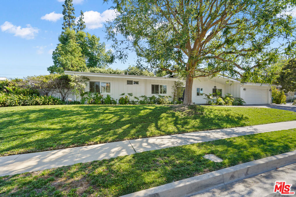 Spectacular Mid-Century Modern architectural with beautiful pool. Designed by Charles Du Bois, AIA, built in 1961. Situated on a quiet, tree-lined cul-de-sac in the coveted West Woodland Hills, this exquisitely remodeled, five-bedroom home blends mid-century architecture with modern, designer finishes, while retaining elements that make MCM special. Warm and welcoming from the moment of arrival, a stone motor court and entry path lead past lush, leafy landscaping to the covered, elegantly lit front patio. The front door opens to reveal the bright, airy interiors offering convenient single-story living, gorgeous hardwood floors, recessed lighting along newer sliding glass doors and windows. Vaulted, beamed ceilings soar above the open-plan living and dining rooms, dual glass chip gas fireplaces, and one custom mantle. The adjacent eat-in chefs kitchen boasts granite countertops, a spacious center island, picture windows, and custom cabinetry. Seamlessly fusing indoor and outdoor living, glass doors open to reveal the spectacular entertainers backyard, featuring a saltwater stone pool and elevated spa. Surrounded by mature trees and privacy hedges, the resort-like grounds boast a stone patio with ample space for alfresco dining and lounging, as well as a flat grass lawn and tree-shaded path ideal for play. Five beautiful bedrooms and three baths include the stunning primary suite with a huge soaking tub and seamless glass and steam shower with rain head. Additional features include brushed nickel and oil-rubbed hardware and fixtures, plantation shutters throughout, and a two-car garage. Private and serene, this 2,900 sqft on a 10,832 sqft lot home feels worlds away while located just moments from Woodland Hills top-rated schools, outdoor recreation, parks, shopping, dining, and 101 freeway access. It is also close to Bristol Farms, the Calabasas Farmers Market, shopping at The Commons, and The Village/Westfield Topanga. A move-in-ready opportunity for a stylish Charles Du Bois home. Offers due 10/13/2025 at 5 PM.