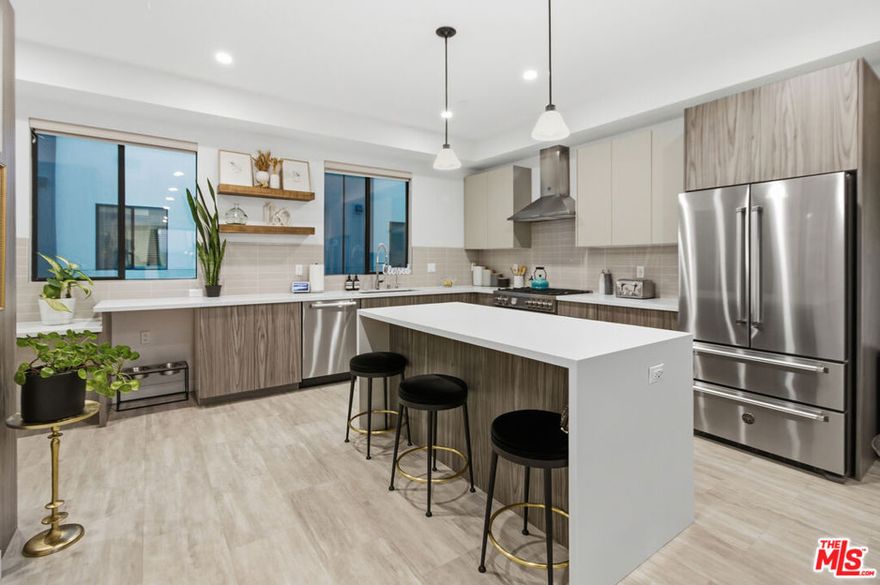 Welcome to Midvale Village! Experience elevated living at 6707 N. Sepulveda , a sleek, contemporary four-level, 4 bedroom, 3 1/2 bath residence that perfectly blends style, comfort, and sophistication in the heart of Van Nuys. Sun-drenched interior, 10-foot ceilings, and an open-concept design create a bright, inviting atmosphere ideal for both relaxing and entertaining. Level one features a full bedroom with an en-suite, perfect for guests, a home office, or multi-generational living. Level two features the main living area, offering a seamless flow between the modern kitchen with quartz countertops, waterfall island, dining area, and living room space, complemented by a convenient powder room for guests. Level three hosts a full bathroom, three bedrooms, including the luxurious primary en-suite and walk-in spacious closet, designed for privacy and comfort with elegant finishes. Ascend to the 4th-level rooftop, a spectacular retreat showcasing 360-degree views of city lights and iconic palm trees, ideal for entertaining or enjoying serene evening views. Additional features include an attached two-car garage with direct access and a 220V outlet for electric car charging, gourmet appliances, soft close custom cabinetry, tankless water heater, second level open balcony with additional storage, dual FAU heating and cooling system, and in-unit laundry closet. Midvale Village is a prime location near dining, shopping, and major freeways. This turnkey Van Nuys home delivers luxury, modern design, and exceptional functionality, crowned by  unforgettable breathtaking rooftop views! This is the home that you have been waiting for. Schedule your tour today!