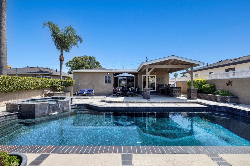 Still dreaming of pool parties and barbecues after the holiday? Say less. Endless summer vibes live here! This turnkey residence has been impeccably cared for inside and out, offering a rare amount of features and upgrades. No doubt about it, the yard steals the show - a true oasis and entertainers dream with its full sized pool and spa, multiple lounging areas, and covered patio with a built-in barbecue and gas line, sink, and counter space; all complimented by sleek charcoal bricks and tile that make it a one of a kind space. The home is equally impressive with its seamless open floor-plan and design. As you enter the house, you are welcomed into the living room fit with multiple windows, a fireplace, and hardwood floors that run throughout the home. It flows into the family room with a built-in entertainment center, and opens up to the chef’s kitchen that offers barstool seating, custom cabinetry, granite countertops with stone backsplash, a farmhouse sink, and a center island. The kitchen connects to the dining area with sliding glass doors that lead directly to the outdoor kitchen, perfect for entertaining and indoor/outdoor meals! This inviting space offers 3 generously sized bedrooms and 2 bathrooms; one of which includes the primary bedroom with abundant closet space and built-ins, and a newly remodeled ensuite bathroom with dual sinks. Some of the hidden upgrades include solar panels, brand new pool equipment, an 8 year old roof, a retrofitted foundation, new copper plumbing, rain gutters, sprinklers, 220V in the garage for EV’s and power tools, vinyl electric gate and fencing with locks, security cameras, central AC and heat, recessed lighting, dual panel windows, plantain shutters, electric blinds, and the list goes on! The massive lot hosts a 2 car garage behind the pool with a large concrete pad perfect for lounging, parking extra cars, or adding an ADU (buyer to verify). The stunning curb appeal, interior functionality and charm, and backyard haven captures your attention and desire from every aspect, making this property a true luxury that you get to call home. Nestled in the heart of San Pedro, this Holy Trinity area home makes it easy to get on and off the hill to restaurants, stores, parks, and beaches; and is great for commuters that need access to freeways. Whether you like to entertain or prefer peace and privacy, this home is the perfect sanctuary for you to enjoy. Don’t miss the opportunity to own your permanent getaway!