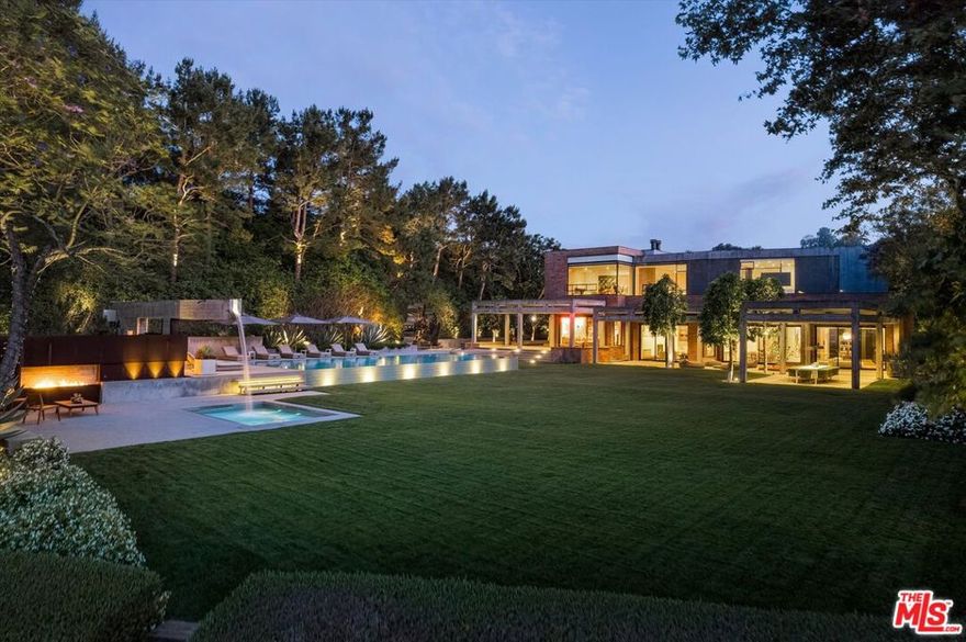 Located in coveted Stoneridge Estates, an exclusive 11-home guard-gated community, this one-of-a-kind, custom 11,000+ SF home was designed by renowned architectural firm, Assembledge+.  Taking form in 2010, the striking contemporary estate uses warm earth tones and textures of brick, wood, glass, smooth concrete and steel delivering a level of sophistication and elegance rarely found at any price point. The property benefits from over an acre of flat, expansive grounds and exceptional privacy. Magnificent scale and soaring walls for art, this residence defines innovative design and sets the standard for luxury living.  Thoughtfully designed with a seamless flow between indoor and outdoor spaces, the home is ideal for entertaining. Additional amenities include zero edge pool, expansive flat grassy yard, outdoor dining room, built-in BBQ area, outdoor fire feature, professional grade screening room, private guest quarters, wine cellar, city light views, grand motor-court, home-automation featuring Lutron | Ketra lighting and 2N security. Property may be delivered fully furnished.