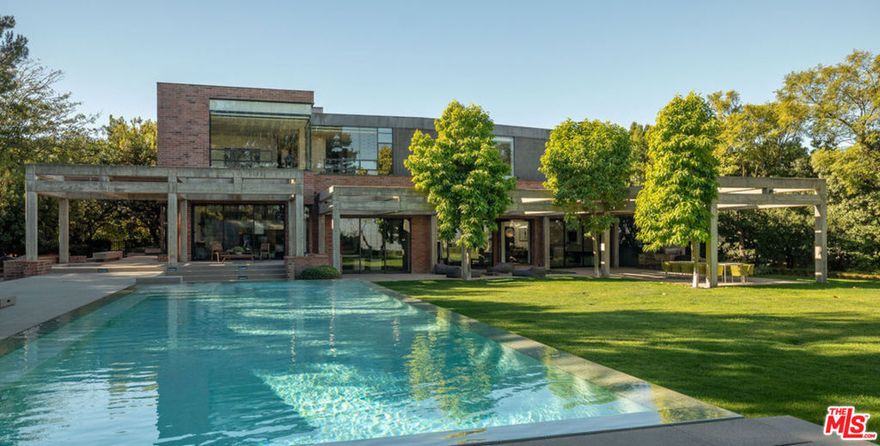 Located in coveted Stoneridge Estates, an exclusive 11-home guard-gated community, this one-of-a-kind, custom 11,000+ SF home was designed by renowned architectural firm, Assembledge+.  Taking form in 2010, the striking contemporary estate uses warm earth tones and textures of brick, wood, glass, smooth concrete and steel delivering a level of sophistication and elegance rarely found at any price point. The property benefits from over an acre of flat, expansive grounds and exceptional privacy. Magnificent scale and soaring walls for art, this residence defines innovative design and sets the standard for luxury living.  Thoughtfully designed with a seamless flow between indoor and outdoor spaces, the home is ideal for entertaining. Additional amenities include zero edge pool, expansive flat grassy yard, outdoor dining room, built-in BBQ area, outdoor fire feature, professional grade screening room, private guest quarters, wine cellar, city light views, grand motor-court, home-automation featuring Lutron | Ketra lighting and 2N security. Property may be delivered fully furnished.