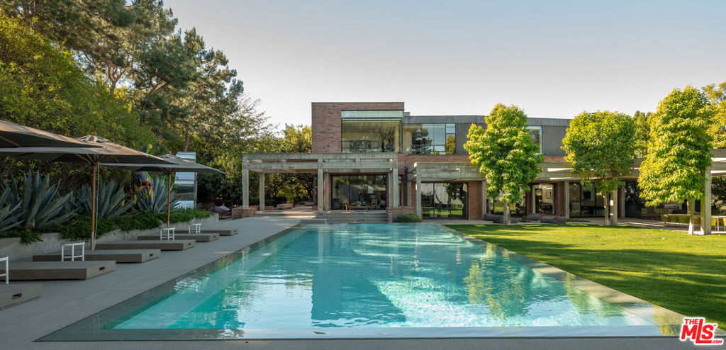 Located in coveted Stoneridge Estates, an exclusive 11-home guard-gated community, this one-of-a-kind, custom 11,000+ SF home was designed by renowned architectural firm, Assembledge+. Taking form in 2010, the striking contemporary estate uses warm earth tones and textures of brick, wood, glass, smooth concrete and steel delivering a level of sophistication and elegance rarely found at any price point. The property benefits from over an acre of flat, expansive grounds and exceptional privacy. Magnificent scale and soaring walls for art, this residence defines innovative design and sets the standard for luxury living. Thoughtfully designed with a seamless flow between indoor and outdoor spaces, the home is ideal for entertaining. Additional amenities include zero edge pool, expansive flat grassy yard, outdoor dining room, built-in BBQ area, outdoor fire feature, professional grade screening room, private guest quarters, wine cellar, city light views, grand motor-court, home-automation featuring Lutron | Ketra lighting and 2N security. Property may be delivered fully furnished.