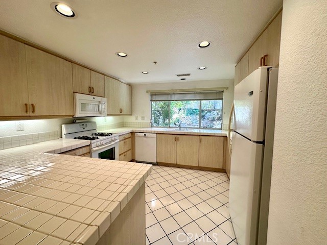 Fabulous home including 3 bedrooms, 2.5 bathrooms, a two car attached direct access garage, HUGE backyard and A/C. If you enjoy outdoor space, this unit has one of the largest backyards in the community with tons of beautiful landscaping and privacy. This home has 1,692 sqft with abundant natural light. The living room features a gas fireplace and a sliding glass door providing access to your backyard, which is low maintenance. The kitchen features white countertops, plenty of cabinetry, a gas range and oven, refrigerator and microwave. Downstairs features a guest half bath as well as a laundry area with a GE washer & dryer included without warranty. Large utility closet under the stairs has plenty of storage space and some shelving. Located upstairs are 3 bedrooms and 2 bathrooms. The ensuite primary bedroom has vaulted ceilings, two mirrored closets and a private balcony facing your backyard. The primary bathroom has dual sinks, a walk-in shower and a separate lavatory area. One of the guest bedrooms features a spacious walk in closet, vaulted ceilings and an ensuite bathroom with a walk-in shower. The other guest bedroom has vinyl floors, built-in Bose Home Theater system and balcony access. Every bedroom features ceiling fans and carpeted floors. HOA features include an ocean view pool and spa. Nearby amenities include hiking trails and the Rancho San Clemente Sports Park. A beautiful place to live near San Clemente High School, loads of shopping and the Pacific Ocean.