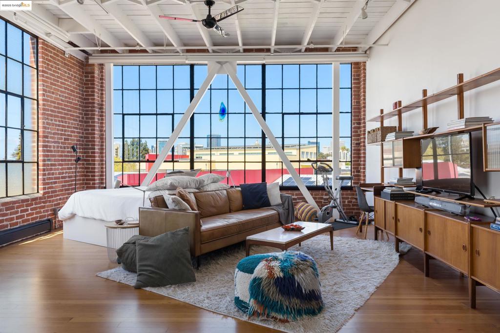 Stunning top floor corner unit overlooking the Laney soccer field and with Skyline views towards downtown. This secure building with deeded secure gated parking is a stunner. Remodeled with floor to ceiling cabinetry in the chef’s kitchen with 5 burner Bosch stove, vent hood and dishwasher, plus almost floor to ceiling wardrobe in the remodeled bathroom (with more storage above). On demand hot water and Hydronic heating and in unit laundry. Automated Roller shades deploy to shield you from the abundant afternoon light that streams in thru the massive & gorgeous metal framed windows. Seismic retrofit steel beams and 2 ceiling fans add a functional & beautiful industrial touch complementing the 14’ high ceilings, exposed brick walls and refinished softwood floors. One of the most impeccably well-run condos by Lake Merritt with a recent roof replacement, healthy reserves and low monthly fee $498.26 monthly. Plus: Secure mail area, freight elevator or internal stairwell entry, community BBQ area & secure assigned storage. Easy walk to Lake Merritt BART, Lake Merritt and the Oakland Museum’s weekly Friday night events!!