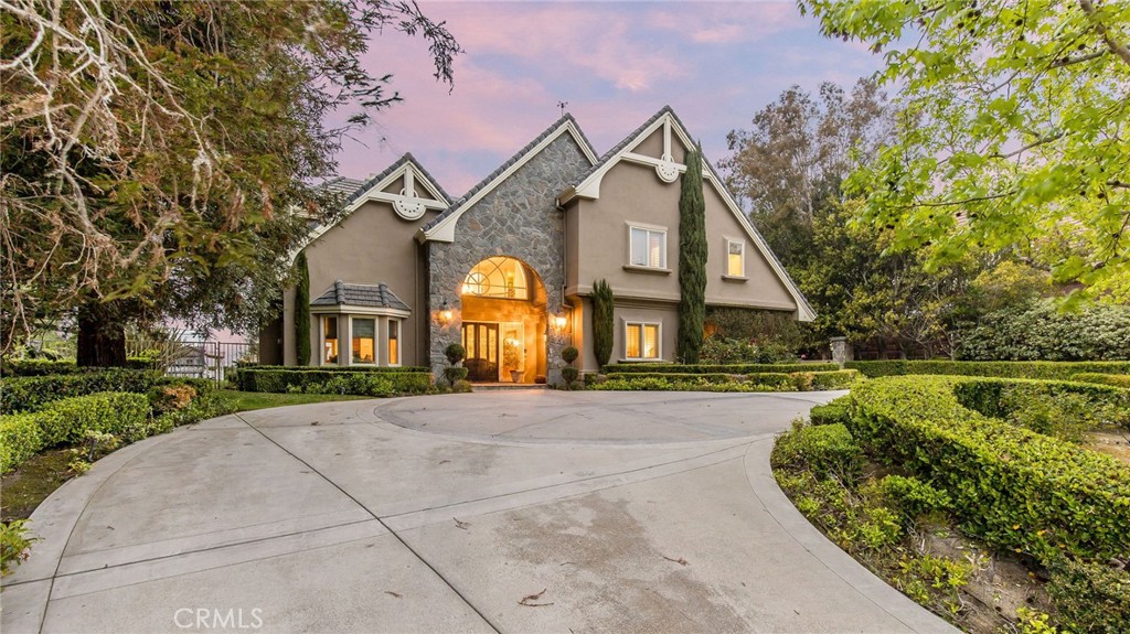 Nestled in the exclusive guard-gated community of the Hunt Club, this custom 5-bedroom, 4.5-bath estate offers over 6,800 square feet of refined living space on a private, beautifully landscaped lot in the heart of San Juan Capistrano.
From the moment you step through the front doors, you’re welcomed by soaring ceilings, rich hardwood floors, and a dramatic entry that opens to elegant formal living and dining spaces—perfect for entertaining. The layout seamlessly blends luxury with livability, featuring a dedicated office with fireplace, spacious media room, and multiple indoor/outdoor gathering areas.
The gourmet kitchen is a chef’s dream, complete with top-tier appliances, an oversized center island, custom cabinetry, and a walk-in pantry. It flows effortlessly into the expansive family room with a cozy fireplace and views of the backyard oasis.
Upstairs, the primary suite offers a private retreat with its own fireplace, spa-inspired bathroom, generous walk-in closet, and a balcony overlooking panoramic views of the surrounding hills and golf course. Four additional bedrooms are generously sized, with ample storage and well-appointed bathrooms.
The resort-style backyard is an entertainer’s dream, featuring a sparkling pool and spa, built-in BBQ island, gazebo, and multiple lounge areas. A circular driveway, four-car garage, and lush mature landscaping complete the property.
Located just minutes from award-winning schools, historic downtown, coastal trails, and Orange County beaches, this one-of-a-kind home offers space, privacy, and sophistication—all in one of the most sought-after communities in South Orange County.