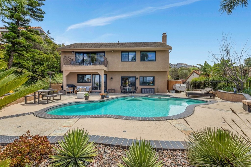 Perched in the coveted Ridgeview Anaheim Hills community is 6441 E Ridge Glen - a five bedroom entertainers dream with sweeping views ~ available furnished or unfurnished! From the moment you arrive, aluminum-glass garage doors & impressive front door set the stage for the upscale experience to come! Enter the home onto luxury laminate flooring into a gorgeous vaulted entry crowned with a modern chandelier. New windows allow soft light to pour into the large living room anchored with a floor to ceiling stone fireplace. Adjacent you will find a gorgeous tray ceilinged dining room currently housing a pool table for evenings of fun with friends. The large chefs kitchen with abundant white floor to ceiling cabinetry looks out over the pool & opens to a large dining space framed with a new slider overlooking your private backyard. A wonderful family room with another floor to ceiling stone fireplace features a new slider & multiple windows framing magnificent views. Shake up your guest’s favorite drinks in your built in bar, perfectly positioned between the dining room, family room and backyard sliders for optimal entertaining. The irresistible views at this point will lure you outside to a massive private backyard where multiple areas await - Al fresco dining, lounging by the sparking pool, soaking in the steamy jacuzzi - all with gorgeous unobstructed views. Back inside designer accent wallpaper adorns the barn doored powder room & just down the hall is your laundry room, complete with washer & dryer, & access to your 3 car garage. The contemporary designed home softened with warm finishes is on brilliant display as you ascend the modern staircase to five glorious rooms. The primary suite wows in so many ways - vaulted ceiling, designer mirrored closet doors, custom wood paneling, insane vistas from the private balcony, en suite spa like bath finished in gorgeous tile with freestanding bath & custom designed built in lighted closet. 3 additional view bedrooms, a huge "flex" room - ideal as a playroom, office or additional suite - another sizeable balcony, a gorgeously updated bathroom & more storage complete upstairs. Ridgeview residents enjoy private tennis courts, community pool, clubhouse, award winning schools, hiking, golf, parks & close proximity to all the amazing So Cal attractions. Blending modern upgrades with timeless warmth, this home is more than a residence—it’s a lifestyle. Don’t miss the chance to make it yours!