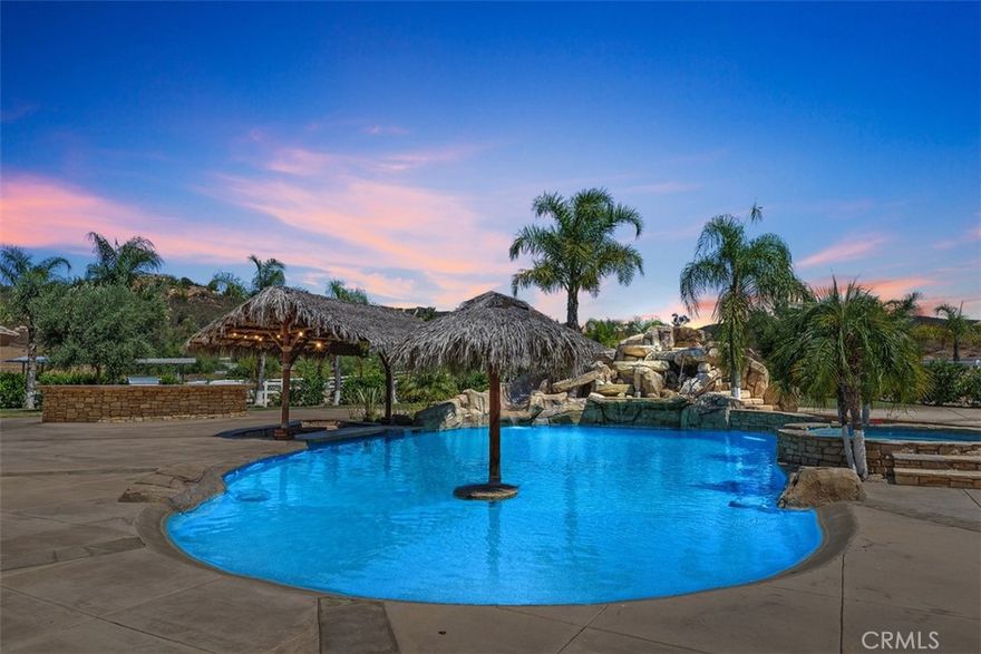 Discover the perfect blend of luxury, privacy, and functionality in this single-story estate, nestled in the prestigious La Cresta community. Set on a fully usable, flat parcel accented by natural rock outcroppings, this custom-built home offers designer finishes throughout, 6" exterior insulated walls, and a lifestyle defined by both sophistication and comfort. Step into a grand great room with soaring vaulted ceilings, handcrafted cedar beams, and a dramatic stone fireplace. The expansive, open-concept layout is anchored by a chef’s kitchen, recently upgraded with modern cabinetry, sleek countertops and premium fixtures. Take in panoramic views of the surrounding foothills through the expansive kitchen windows, blending natural beauty with refined living. The thoughtfully designed split-bedroom floor plan includes a luxurious primary suite tucked away for privacy, featuring a spa-inspired en-suite bath and a cedar lined walk-in closet. Secondary bedrooms include a Jack-and-Jill suite and a versatile bonus room with its own fireplace and bath—ideal for a guest retreat, game room, or mother-in-law quarters.  All bathrooms throughout the home have been tastefully remodeled with designer selected finishes, elevating both style and comfort. The interior also offers an oversized laundry room with additional storage, utility sink, and central vacuum system. A covered breezeway leads to a 1,200 sq. ft. finished garage deep enough for large trucks or sports cars, complete with a workshop area and utility sink.

Outdoors, your private resort awaits. Enjoy a 50,000 gallon custom pool with beach entry, 10-foot deep end, spa, rock waterfall, waterslide and swim up bar—surrounded by lush landscaping. Gather around the built-in firepit, or entertain under the stars at your outdoor kitchen, featuring a built-in BBQ, spacious prep counters, and a two-burner cooktop. A private well irrigates the entire landscape and outdoor features . Equestrian amenities include two in-and-out corrals with stud panel fencing, large pasture, a tack/feed/storage room, and a riding trail encircling the property. You’ll also find a chicken coop, fruit trees, and raised garden beds, with extra space to expand and bring your outdoor hobbies to life.

The La Cresta lifestyle, where luxury meets freedom and nature. Move-in ready and rich in opportunity, this estate is ready to welcome its next discerning owner.