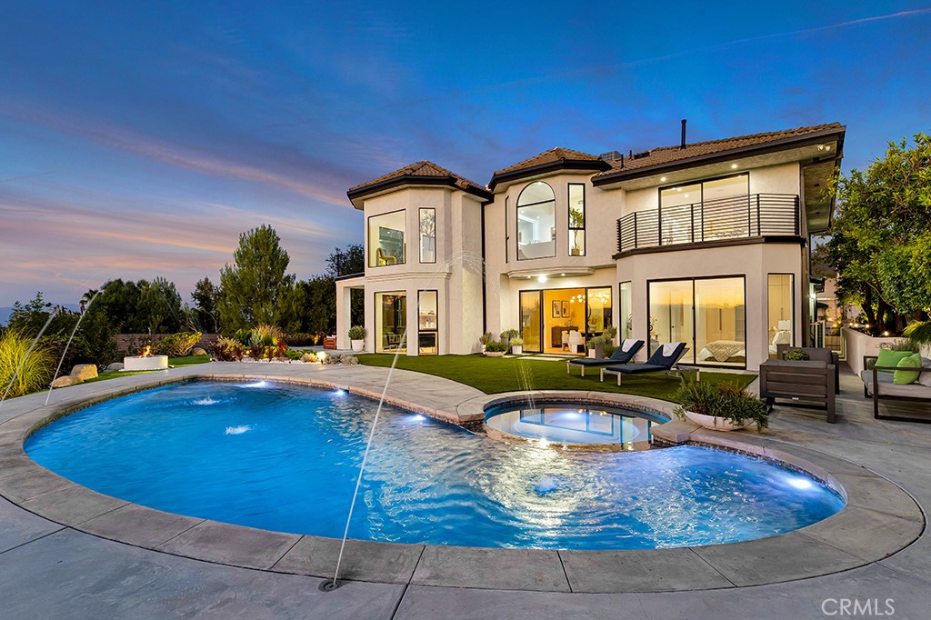 Welcome to 4015 Clarinda Drive, a newly remodeled contemporary estate in one of Tarzana Hills most coveted neighborhoods, offering 5,100 sq ft of elite luxurious living on an expansive 18,819 sq ft lot with breathtaking panoramic views from virtually everywhere on the property. Seller recently invested over $1,000,000 to remodel the entire home with custom high end expensive finishes throughout. The oversized open floor plan showcases soaring ceilings, Restoration Hardware chandeliers and light fixtures, LED mirrors, new doors and windows, custom cabinetry, wide-plank hardwood flooring, and so much more. A designer's dream of a gourmet chef’s kitchen features true seductive warm flow, a large stone island, brand new Thermador appliances, sensational views, and an abundance of space to entertain. The massive living room has a romantic oversized fireplace, sleek wet bar, exit doors to the yard, and crisp lines. The primary suite is a gorgeous private retreat complete with a modern fireplace, custom walk-in closets with LED lighting, and a spa-inspired ensuite bathroom with dual vanities, an oversized glass shower, and a freestanding soaking tub framed by floor-to-ceiling windows capturing stunning valley views and cascading illuminating natural light. The additional bedrooms are generously sized, each boasting their own designer bathrooms with modern stonework and fixtures. For added convenience, the home includes two laundry rooms, and plentiful storage space. The backyard is designed for upscale resort-style living, with a brand-new pool and spa, built-in BBQ, fire pit lounge area, lavish landscaping, expansive turf lawn, new security gates, sophisticated outdoor lighting, custom hardscape and walkways, and intimate entertaining areas everywhere—all set against massive sweeping city and mountain views. You will enjoy epic daily sunsets with glorious cotton candy skies and the utmost in exclusivity and privacy. Additional upgrades include modern garage doors, gorgeous fireplaces, elegant pivot entry door, new A/C units, tankless water heaters, detailed carpentry, and custom designed closets throughout. Situated only minutes from Ventura Boulevard’s premier shopping, high-end dining and entertainment, this move-in ready estate offers the ultimate luxurious Tarzana family living.