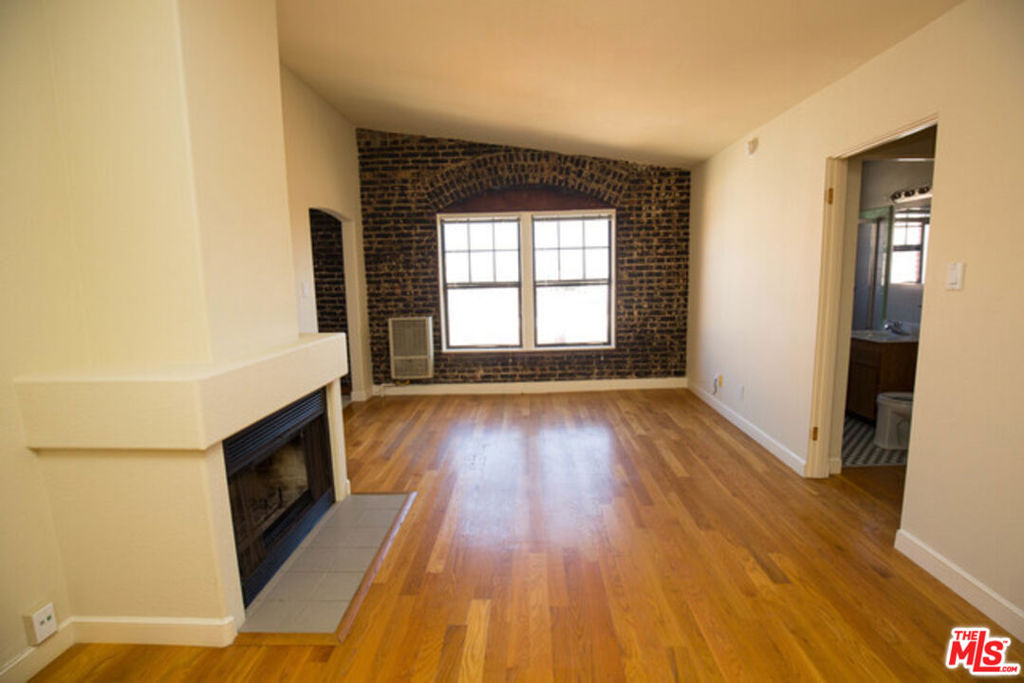 Beautiful top single apartment with exposed brick. This is a must see! The unit comes with hardwood floors, full kitchen, fireplace, office and a full bathroom. Two closets offer plenty of storage. Located on a beautiful treelined street between Wilshire and 3rd. Walk to cafes, coffee shops and the Grove. Parking is off street and permitted through the city. Building is secure with code for entry. Laundry room is located within the building. Pictures are of a like unit.