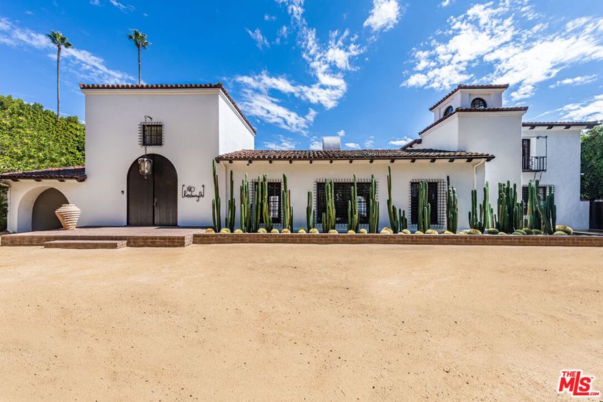 Immortalized on the cover of Architectural Digest and published in several editions, this rare Spanish Colonial on iconic Roxbury Drive in the Beverly Hills Flats offers 6BD, 9BA and effortlessly blends timeless architecture with modern sophistication. Originally designed by Ralph Flewelling, FAIA, the approx. 8,434 SF residence has been exquisitely updated to preserve its historic elegance while introducing contemporary comforts. Archways, soaring truss ceilings, wrought-iron accents, and hardwood and terracotta floors create a dramatic yet inviting atmosphere.The main living spaces open to a serene central courtyard with sitting areas and fountain, while a grand entry hall doubles as a stunning library with groin-vault ceilings. Formal living and dining rooms, a den/media room, office, and a spectacular kitchen with adjoining great room provide ample space for both entertaining and everyday living. Two guest bedrooms on the main level are complemented by four upstairs, including a majestic owner's suite with fireplace, dual baths, and balconies overlooking the courtyard and grounds.Outside, lush landscaping frames multiple seating and dining areas, a sparkling pool and spa, sports court, and a charming guest house, offering the perfect blend of privacy and resort-style living. A legacy property where Hollywood glamour meets modern luxury. Now is your opportunity to become part of the impeccable pedigree of ownership.