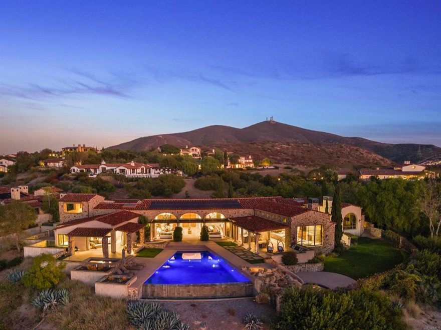 Nestled in the guarded enclave of Santaluz, 8114 Sendero de la Pradera is a 2015 Mark Agee custom built masterpiece located on the 17th hole of this stunning Rees Jones championship golf course. Spanning over 10,800 sq ft on a one-acre parcel, this elegant estate offers 5 bedrooms, 8 baths, and breathtaking ocean, valley, and mountain views. Seamless indoor-outdoor living features a vanishing-edge infinity pool, separate spa, a secondary pool with slide and al fresco entertaining pavilion. Detached, self-contained casita provides comfort for short- or long-term guests. The gourmet chef’s kitchen boasts premium appliances and marble finishes and custom cabinetry . Enjoy a private theater, game room, soundproof music studio, five-car garage, owner-owned solar, and whole-home water filtration. This property is the pinnacle of luxury, refinement, and privacy, ideally suited as an Entertainer’s CROWN JEWEL.