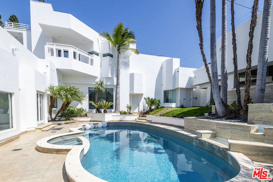 Welcome to 6710 South Garth Avenue, an entertainer's dream home on an expansive 11,070 sq ft lot in the heart of Ladera Heights. Enter through a striking 8-ft custom glass pivot door into a dramatic 16-ft high foyer that sets the tone for this one-of-a-kind 5-bedroom, 4-bath residence. The custom chef's kitchen showcases dark wood cabinetry, sleek quartz countertops, and a central island. A sunken living area with fireplace frames views of the sparkling pool, while the large formal dining room is ideal for memorable gatherings. The expansive family room, with soaring ceilings and oversized windows, opens to the lush yard, while an adjacent bonus room offers flexibility as a game room, media lounge, studio, or gym. On the first floor, an en suite guest wing provides the perfect in-law or private suite. Upstairs, the secluded primary retreat is the only room on the upper level - it features its own fireplace, a spa-inspired bath with soaking tub and oversized shower, an illuminated custom dressing room with skylight, and two private decks with sweeping city-light views. The backyard delivers resort-style living: a waterfall cascading into the tiled pool and spa, outdoor Viking kitchen and bar, fire pit lounge, and a covered outdoor living room with fireplace designed for effortless entertaining. With four fireplaces, two private decks, an attached 3-car garage plus 2-car covered carport, and a prime Westside location near Silicon Beach, Playa Vista, and Culver City, this home embodies the very best of Los Angeles luxury living.