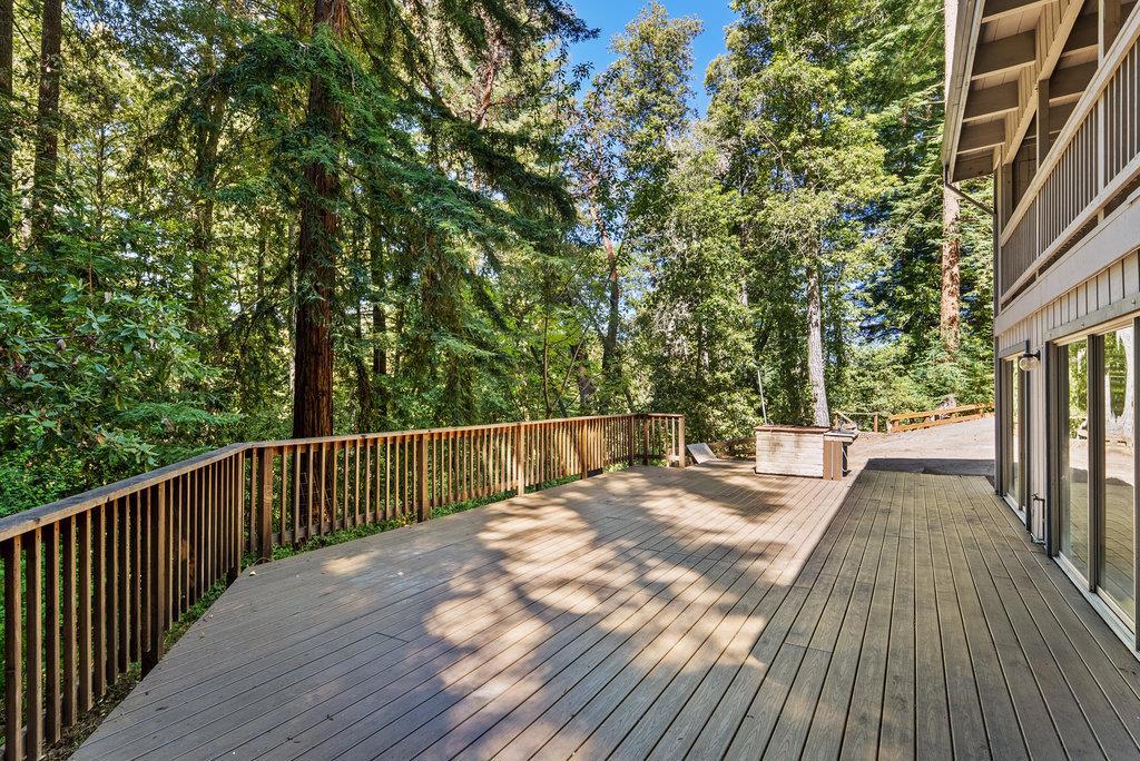 Nestled among majestic Redwoods, 125 Carl Drive offers a rare blend of privacy, natural beauty, and custom craftsmanship. Set back from the road down a private driveway, this thoughtfully designed two-story home features a unique reverse floor plan and was custom built by its original owners. The main level boasts a spacious living room with striking exposed beam ceilings, a custom stone fireplace, and a spiral staircase that adds both character and function. Downstairs, you'll find three well-appointed bedrooms, two full bathrooms, and a comfortable family room, perfect for everyday living or hosting guests. Additional highlights include a third bathroom on the main level and a wraparound Trex deck, installed just three years ago, ideal for enjoying the serene forest setting. Conveniently located just off Highway 17 in Scotts Valley, this home offers an excellent commute to San Jose while keeping you close to downtown Scotts Valley and the beaches of Santa Cruz.