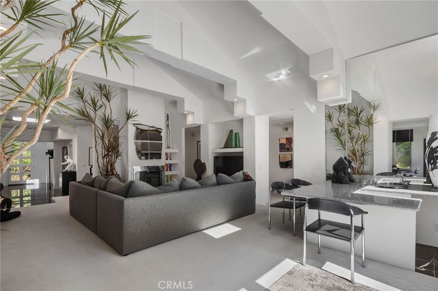 Located on a private, gated street, this architectural home offers a rare blend of sophistication, comfort, and resort-style living. Far from the typical home, it’s designed to inspire—balancing striking design with a warm, livable flow ideal for an active way of living and effortless entertaining. Step through the grand foyer into a beautifully appointed interior where natural light, soaring ceilings, and dramatic architectural elements create an atmosphere of elegance and ease. The chef’s kitchen opens seamlessly to the expansive living and dining areas, perfect for gatherings both large and intimate. The first level features two generous bedrooms sharing a Jack-and-Jill bath, plus an additional ensuite bedroom and a convenient laundry room. Upstairs, the spectacular primary retreat feels like a private sanctuary—complete with a loft, romantic fireplace, private balcony, and great natural light. The sumptuous bath features dual vanities, a spa tub, separate shower, and a spacious walk-in closet. Additional highlights include a 3-car garage with direct access, a modern home security system, and an adaptable floor plan that can be easily customized to suit any taste or design aesthetic. Outdoors, the home truly shines—a private backyard oasis surrounded by mature trees and lush greenery. Enjoy a tranquil pool and spa, BBQ center, and patio designed for entertaining or relaxing. The PRIVATE TENNIS COURT is easily converted to a PICKLEBALL COURT, or the space could be reimagined as a guest house, music studio, or other creative retreat, offering endless possibilities on this large, beautiful lot. This house is a vibe—architectural, private, and truly a rare find.