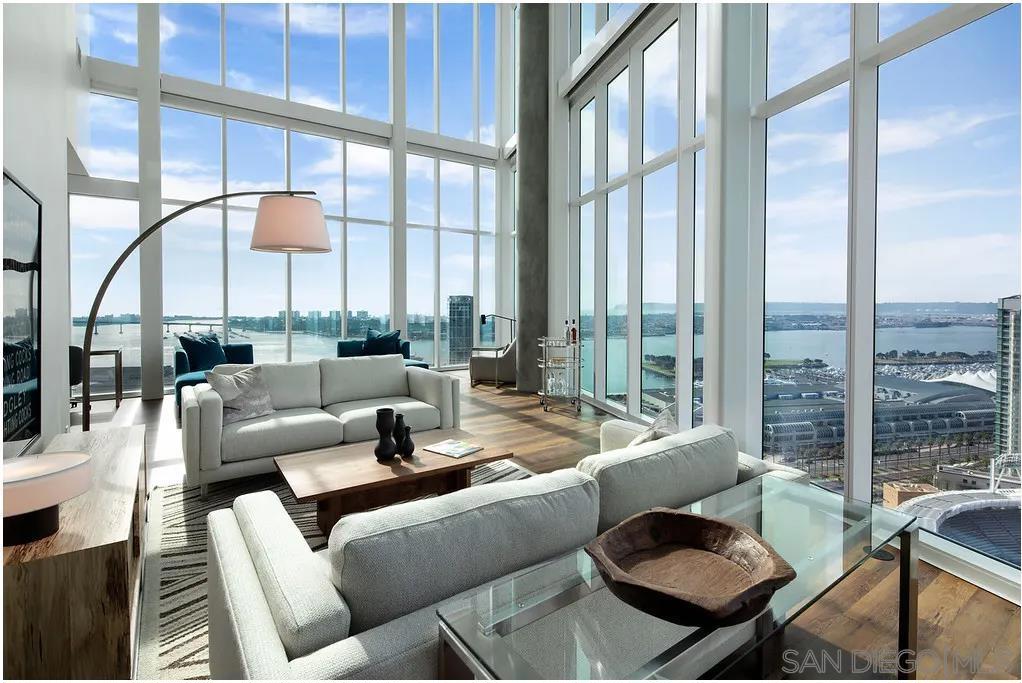 Experience elevated penthouse living at Park 12 in the heart of downtown San Diego. This one-of-a-kind residence boasts soaring 40-foot ceilings, dramatic floor-to-ceiling windows, and remote-controlled roller shades that frame breathtaking city views. From your expansive private balcony, enjoy a direct sightline into Petco Park—perfect for catching Padres games and concerts from home. The interior showcases polished quartz countertops, high-gloss cabinetry, polished chrome fixtures, and upgraded appliances, including a built-in refrigerator and wine fridge. Spa-inspired bathrooms feature TVs in the mirrors, a soaking tub, and walk-in shower. As a resident of Park 12, indulge in world-class amenities: a 24-hour indoor/outdoor fitness center, heated saltwater pools, sports lounge with arcade games and bowling lanes, and a co-working lounge. Modern architecture, enviable amenities, and unrivaled views make this penthouse the ultimate expression of downtown San Diego luxury.