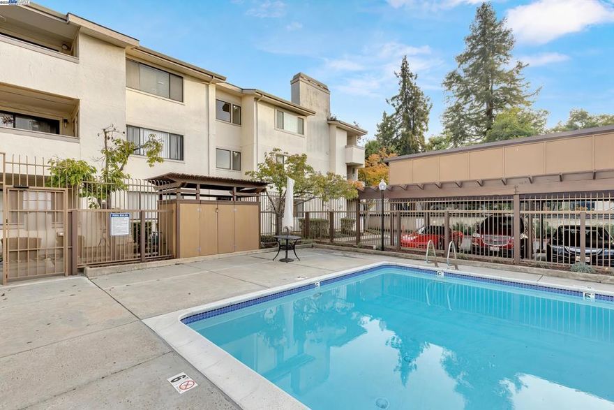 Boasting 1,360 sqft. this oversized 2 bedroom, 2 bath condo is located in the heart of Fremont. This ground level, corner unit offers a resort like atmosphere, situated right in front of the pool and spa. Enjoy amenities such as swimming, sunbathing, and other relaxing features. Residents can also enjoy well maintained green spaces and a beautifully manicured lawn throughout the community. Ideally located just 6 minutes from Fremont BART and close to highways 880, 680 & 84. Easy access to Lake Elizabeth Park and convenient shopping options like Target, Ross, & CVS (all 3 mins away), as well as numerous restaurants, including Chili’s (3 mins away). Fremont Hospital is also only 4 mins away. The condo features a split-level layout. Both generously sized bedrooms include walk-in closets; the owner’s suite has its own bathroom, and a 2nd full bathroom is located in the hallway. The kitchen, dining area, and living room are located downstairs, offering an open and inviting space complete with a cozy fireplace and a large sliding door leading to the balcony. The unit also offers in-unit laundry for added convenience. The building provides an elevator for easy access from the gated garage or lobby. Additional benefits include an assigned underground parking space & large storage unit.