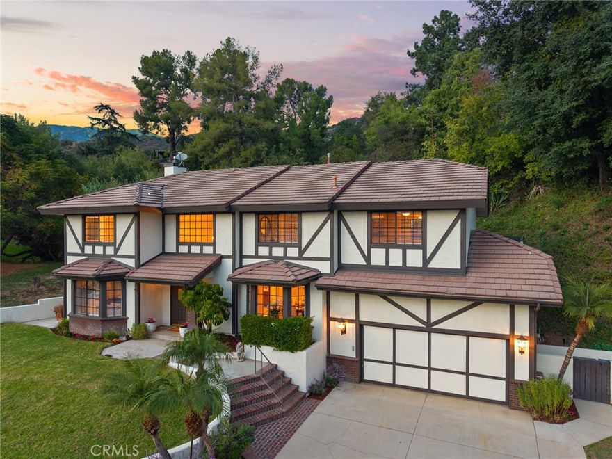 Nestled in one of North Monrovia’s most desirable neighborhoods, this home offers an exceptional blend of privacy, serenity, and natural beauty. Surrounded by lush greenery and peaceful views, it offers a tranquil retreat while remaining just minutes from the historic area of Downtown Monrovia. A charming covered front porch and elegant double-door entry open to a soaring two-story foyer. The bright, expansive living room showcases large windows that frame the scenic surroundings, while the formal dining room, also enjoying the same picturesque views, sits at the center of the home, perfect for gatherings and celebrations. The spacious kitchen features ample cabinetry, a center island with cooktop, and an open layout that flows seamlessly into the breakfast nook and generous family room. Complete with a wet bar, fireplace, and sliding doors leading to an exceptionally private outdoor area, these main living spaces are designed for comfort and effortless entertaining. Enjoy the peace and quiet as you relax in your own natural sanctuary. Upstairs, all four bedrooms offer abundant space and thoughtful design. The expansive primary suite includes a walk-in closet and a well-appointed bathroom with dual sinks and a relaxing soaking tub. Three additional bedrooms provide versatility, including one with direct access to a private deck, an ideal place to take in the tranquil natural surroundings. The remaining two bedrooms capture beautiful city-light views and share a spacious guest bathroom. Additional amenities include a convenient upstairs washer and dryer, tile flooring in the entry, kitchen, and family room, and an attached two-car garage with direct access and extensive built-in storage. The home is located within the sought-after Monrovia school district and close to Downtown Monrovia, where quaint shops, local restaurants, and year-round community events create a welcoming small-town feel.