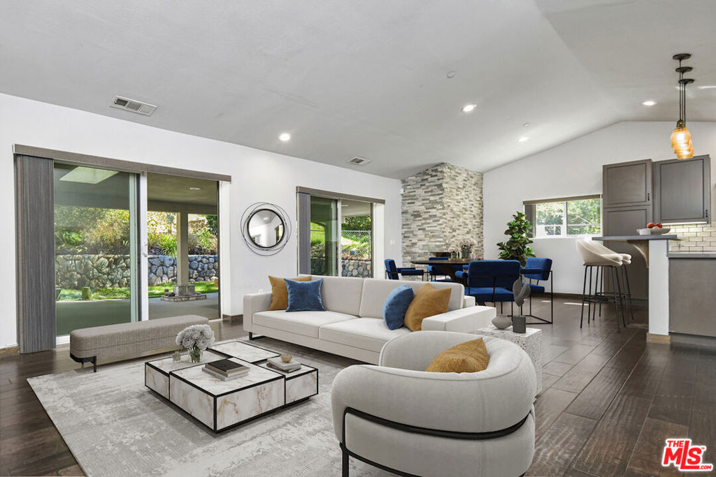 This Awesome ranch style home offers a blend of contemporary design immersed in nature, perched in the hills of Tujunga. Built in 2017 and meticulously well kept, this open-concept, three bedroom and two bathroom retreat is a rare find! Stepping inside, you'll be greeted by the warmth of real Oak hardwood floors, which flow effortlessly throughout the home. A modern kitchen, outfitted with sleek appliances and refined finishes, serve as the heart of the home-perfect for both casual mornings and elegant entertaining. The living area is anchored by a real wood-burning fireplace, creating a cozy ambiance for the cooler nights. Beyond the homes impeccable interior, the private gated driveway ensures both security and seclusion, while dedicated RV parking adds to its practicality. Talk about indoor-outdoor living there is direct access through floor to ceiling glass sliders of which lead to a spectacular patio and sprawling back garden, scattered with flowers and a manicured lawn, a true sanctuary backs up to the majestic mountains and features a natural stream, offering a peaceful oasis where nature and comfort coexist in perfect harmony. This home is more than a residence-its an escape, its an experience, and an opportunity to embrace both modern comfort and breathtaking scenery. An absolute gem in superb condition awaits its next chapter, there is so much room to expand and build up or out. All mounted televisions, brand-new propane washer/dryer and refrigerator are generously included in the sale. Some of the pictures are virtually staged. Priced to sell and motivated Sellers.