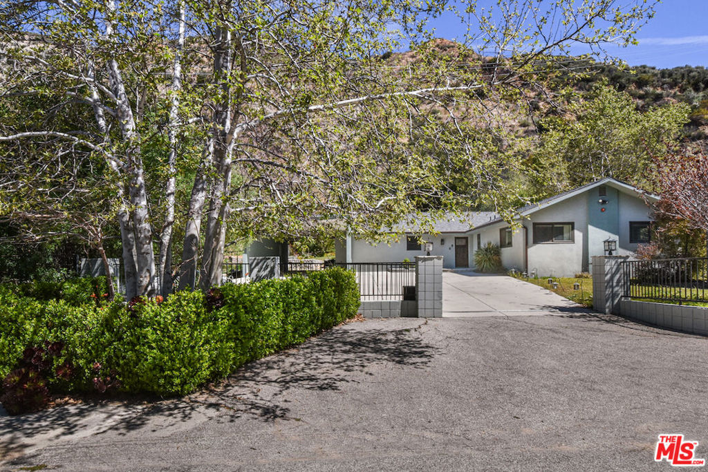 This Awesome ranch style home offers a blend of contemporary design immersed in nature, perched in the hills of Tujunga. Built in 2017 and meticulously well kept, this open-concept, three bedroom and two bathroom retreat is a rare find! Stepping inside, you'll be greeted by the warmth of real Oak hardwood floors, which flow effortlessly throughout the home. A modern kitchen, outfitted with sleek appliances and refined finishes, serve as the heart of the home-perfect for both casual mornings and elegant entertaining. The living area is anchored by a real wood-burning fireplace, creating a cozy ambiance for the cooler nights. Beyond the homes impeccable interior, the private gated driveway ensures both security and seclusion, while dedicated RV parking adds to its practicality. Talk about indoor-outdoor living there is direct access through floor to ceiling glass sliders of which lead to a spectacular patio and sprawling back garden, scattered with flowers and a manicured lawn, a true sanctuary backs up to the majestic mountains and features a natural stream, offering a peaceful oasis where nature and comfort coexist in perfect harmony. This home is more than a residence-its an escape, its an experience, and an opportunity to embrace both modern comfort and breathtaking scenery. An absolute gem in superb condition awaits its next chapter, there is so much room to expand and build up or out. All mounted televisions, brand-new propane washer/dryer and refrigerator are generously included in the sale. Some of the pictures are virtually staged. Priced to sell and motivated Sellers.