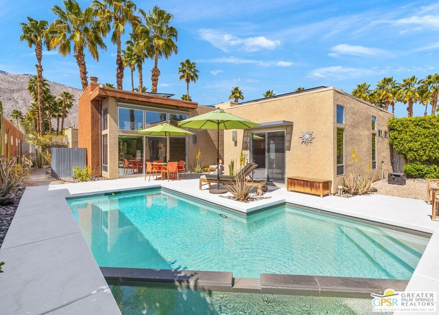 EXCEPTIONAL opportunity to own and enjoy a modernist delight in an ultra-private setting at South Palm Springs! Tucked away, yet perfectly positioned, Dunes Court is a collection of 12 detached homes in the POST-MODERN tradition. Openness, deep overhangs, expanses of glass, and San Jacinto Mountain VIEWS work their magic while a mix of indoor-outdoor conversation areas frame the refreshing saltwater pool + spa. OWNED SOLAR is another pleasant surprise. Take the Matterport VIRTUAL TOUR for a better sense of flow where updated finishes play beautifully alongside the architect's original vision. Natural light is also a theme and plays especially well in the living room with its tall ceilings and modern fireplace. The nearby island-centered kitchen is ready for the pages of Dwell Magazine and opens to an interior courtyard. Onto the ensuite bedrooms which enjoy a nice separation with the Primary Suite positioned at one end of an "all-glass" hallway, definitely one-of-a-kind. Both the primary and Guest Bedroom #2 feature large walk-in closets. Notable upgrades include modernist cabinets and counters throughout, motorized sun shades, remote-control pool system, security cameras, and built-in storage for the 2-car garage. Low HOA dues and Fee Land (you own it) help make this THE ONE to see. The best of Palm Springs, both downtown and the convenient south end of town, are a short hop away. Enjoy it all.