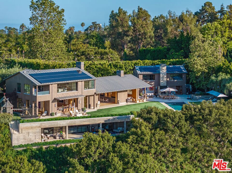 A true sanctuary in every sense, this one-of-a-kind trophy estate by the late, legendary architect Howard Backen sits on the 7th hole of the iconic Riviera Country Club - the only Backen-designed home ever built on L.A.'s premier golf course. Encompassing approximately 12,240 SF, this 6-bedroom, 6-bathroom masterpiece captures sweeping views of the Santa Monica Mountains with some of the most breathtaking sunsets in the city. Backen, renowned for shaping modern California architecture, was a visionary of elegant simplicity, expressive natural materials, and seamless indoor-outdoor living. This home stands as a living tribute to his legacy - crafted with board-formed concrete, vaulted wood ceilings, steel-frame windows, and disappearing glass walls that dissolve the boundary between architecture and nature. Designed to elevate every moment, the estate features a massive motor court, a chef's kitchen, temperature-controlled wine cellar, movie theater, guest house, spa and wellness center, dedicated kids' lounge, and the most iconic man cave ever imagined. Fully powered by geothermal energy, this compound offers off-the-grid living without sacrificing a single luxury. This private retreat sits tucked away on what may be L.A.'s best-kept secret street. The location is unparalleled: discreetly positioned next to Channel Road, it offers quick access to the beaches, Malibu, the Brentwood Country Mart, and some of the finest dining - all while feeling worlds away from it all. Welcome to ground zero for luxury, privacy, and sophisticated Zen living.