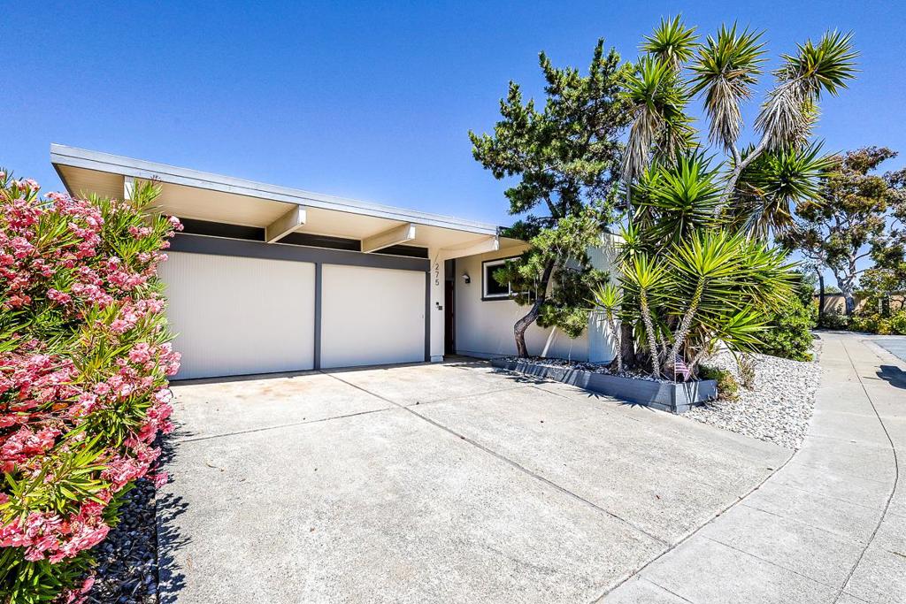 This 5-bedroom, 2-bath Eichler perfectly blends classic mid-century modern architecture with stylish updates. At its heart, a serene open-air courtyard fills the home with natural light, with surrounding rooms framed by floor-to-ceiling windows and sliding glass doors for seamless indoor-outdoor living. The spacious living and dining rooms feature a rebuilt fireplace for warmth and ambiance, plus direct access to both the central atrium and lush backyard. The updated kitchen boasts new countertops, stainless steel appliances, and a cozy breakfast nook. A hallway lined with storage leads to a renovated full bath with dual vanity and five comfortable bedrooms, including a private primary suite. Multiple-zone split AC units in each room ensure year-round comfort. The expansive backyard is perfect for gatherings, barbecues, or quiet relaxation. Located on a peaceful cul-de-sac, just steps from the waterfront, shopping, dining, and parks, this home offers timeless style, comfort, and convenience.