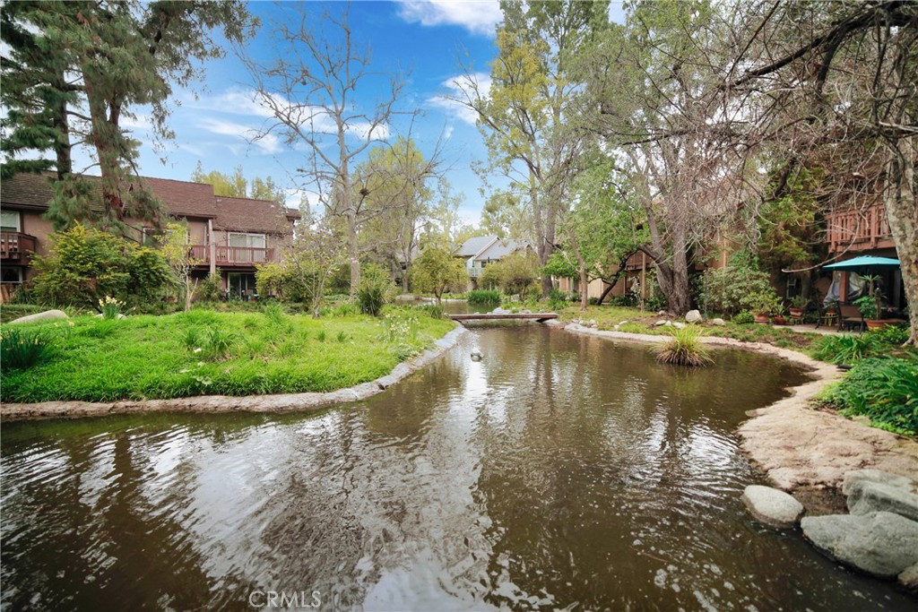 Enjoy stunning views of streams and breathtaking landscapes in this downstairs one-bedroom unit at Canoga Lakes. The unit is in a prime spot within the complex, featuring an outdoor patio perfect for soaking in the peaceful surroundings. Inside, you'll find impressive upgrades like gorgeous wood floors, a completely renovated bathroom, and a modernized kitchen. It comes with two convenient parking spots and is located on the first floor with no stairs. The HOA offers fantastic amenities, including two sparkling pools, two Jacuzzis, a fitness room, lighted tennis courts, and 18 acres of walking paths, lush greenery, and serene sitting areas to take in the scenery. Canoga Lakes is in a lively area close to transportation, hospitals, excellent dining, and entertainment options. You're also near "The Village," Topanga Plaza, Fallbrook Mall, Malibu Wines, and much more. This is a perfect place to unwind and enjoy life—you’ll absolutely love living at Canoga Lakes.