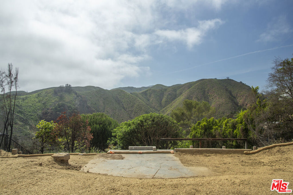 Nestled on a quiet cul-de-sac in the prestigious Upper Riviera of Pacific Palisades, this nearly one-acre property presents an exceptional opportunity to build your dream home in one of Los Angeles' most sought-after neighborhoods. While the previous 5,249 sq ft residence was lost in the Palisades Fire, the lot is now primed for a fresh start with the added benefit of a streamlined, fast-track rebuilding process. Surrounded by $20M+ estates, the property sits among intact homes in a neighborhood with very minimal impact from the fire- creating a peaceful, private setting with a true sense of community. This is a rare chance to design and build a custom estate in a majestic, tranquil location with endless potential surrounded by sweeping views of the Santa Monica Mountains. Phase I & II have already been completed with plans that include an ADU, infinity pool, sauna/gym, and sport court thereby saving valuable time in planning and development. All plans and permits are included in the sale. Property goes well beyond the flat portion of the lot.
