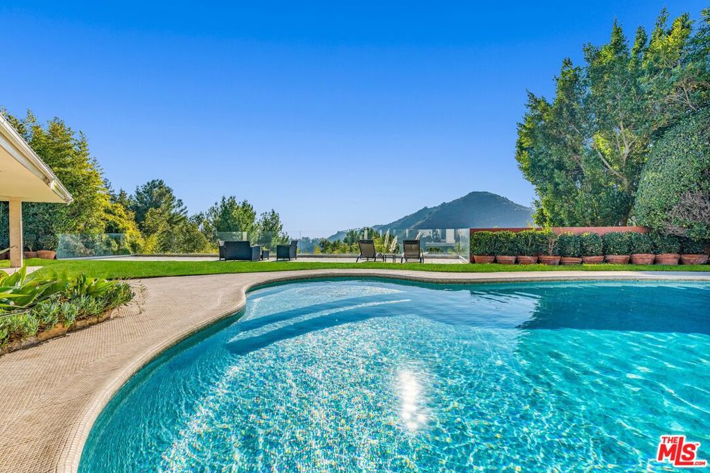 PRIVACY. TRANQUILITY. EVER-CHANGING VISTAS. 4 BEDS/3,5 BATHS PLUS GYM/OFFICE. Tastefully and recently remodeled with HIGH-END LUXURIOUS designer finishes. This SINGLE LEVEL marvelous Mid-Century home is an absolute STUNNER. Boasting PANORAMIC CANYON AND MOUNTAIN VIEWS from ALL the living spaces and bedrooms, this sensational home will take your breath away the moment you step inside. FLOOR-TO-CEILING picture windows, glass doors and abundance of natural light throughout instantly provide the feeling of an open and airy elegance. Featuring an OPEN-CONCEPT, WELL-DESIGNED FLOOR PLAN, this home has a great indoor/outdoor flow. You'll love to host guests and loved ones in the backyard complete with a breathtaking ENORMOUS DECK, a resort-like sparkling pool (featuring lustrous and dazzling glass tiles reminiscent of rainbow-like play of colors), spa, and serene waterfalls. Additional features include one-of-a-kind RAINFOREST MARBLE, ONYX, TRAVERTINE, CEASERSTONE, GRANITE FINISHES, state-of-the-art APPLIANCES, 2 car garage PLUS a circular driveway. Located on a quiet street with no neighbors across, next to the guarded, upscale Beverly Park community. WELCOME HOME!