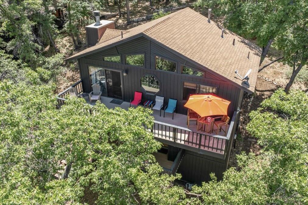 Tucked away in Upper Moonridge, this charming mountain cabin offers stunning panoramic valley views and a secluded 'tree-house' feeling--surrounded by mature oaks and pines on a spacious 12,000 sq ft lot. Whether you're enjoying crisp mountain air and vibrant colors from the elevated front deck or exploring nearby trails, this property delivers the perfect blend of nature, comfort, and convenience. Inside, the well-maintained home features vaulted ceilings, knotty pine accents, and beautiful wood laminate flooring throughout, creating a warm and inviting mountain feel. The upgraded kitchen is equipped with stainless steel appliances and blends seamlessly into the open living space, where an impressive river rock wood-burning fireplace adds cozy ambiance on chilly evenings. Modern upgrades include forced air heating, updated bathrooms, and underground utilities offer unobstructed views. A generous under-house storage area is ideal for bikes, kayaks, or winter gear, making this home as functional as it is beautiful. Located just minutes from Bear Mountain Ski Resort, golf, Big Bear Lake, and The Village, and with easy access to nearby hiking and biking trailheads, this property is perfectly positioned for year-round adventure. Furnishings are negotiable, offering a turnkey option for a primary residence, vacation home, or investment cabin.