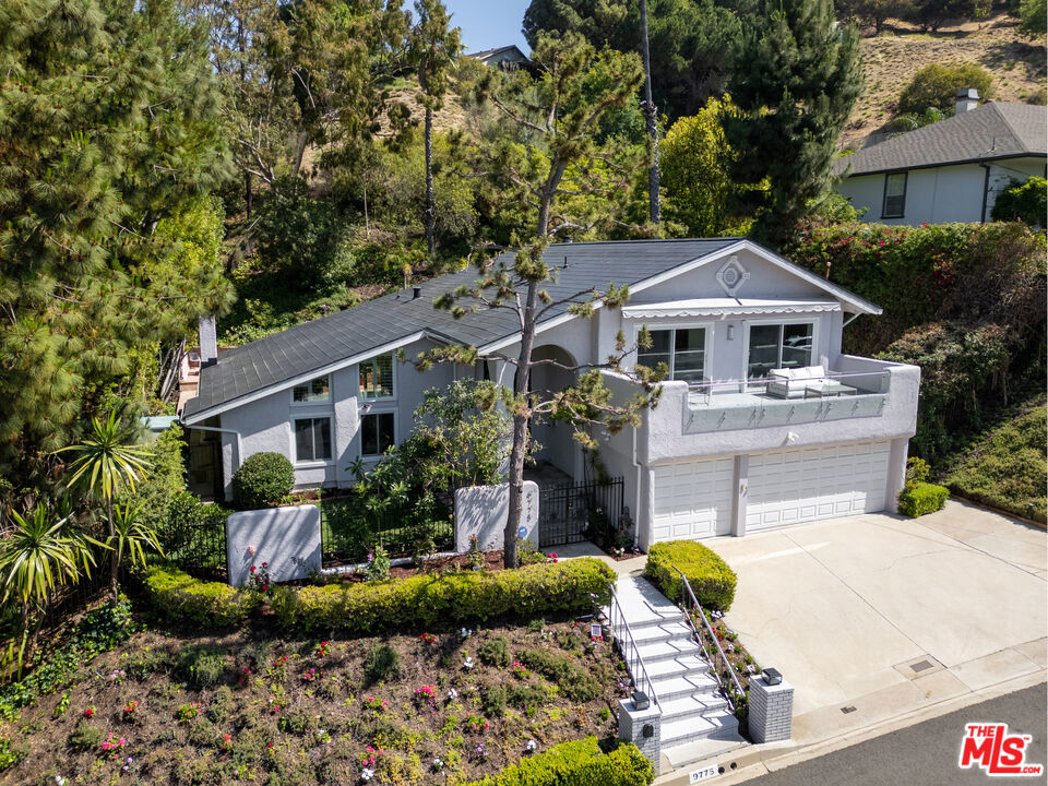 Beautifully updated 5BD/4BA home offering approx. 3,400 sq ft of refined living on a quiet cul-de-sac. Elevated above street level with a tiered yard and wide entry, the home features a shared front balcony with canyon views. Inside, a newly upgraded massive floor-to-ceiling iron pivot door and picture window highlight soaring ceilings, Brazilian rosewood floors, Andersen dual-pane windows, and a custom glass-railed staircase. The open layout includes a den with fireplace and direct access to a private backyard with 40-ft pool, spa, and lush landscaping.The gourmet kitchen features a 48" Sub-Zero fridge, Viking cooktop, Miele oven/steamer, granite island with prep sink, stainless backsplash, and RO hot water system. Upstairs, the private primary suite includes a fireplace, walk-in closet, and spa-style bath. Notable upgrades include a newly installed Tesla Solar Roof plus Power Wall (owned), Tesla EV charger, new Lennox high-efficiency HVAC with heat pump (AC & heat), security cameras, digital code entry, dedicated laundry, spacious pantry and wide driveway also Beverly Park security patrol provides added neighborhood supervision. Minutes from Beverly Hills, Mulholland, and Sunset.