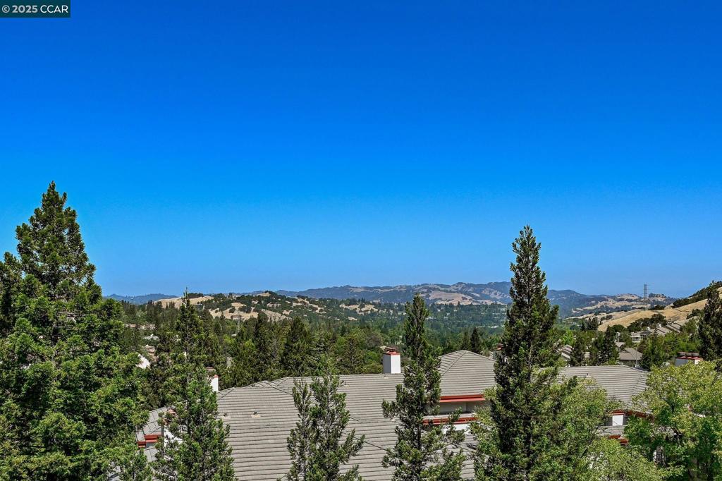Spectacular views of the hills near and far, surrounded by beautiful trees. Peaceful location in the hills of the community, this desirable Summit model is a single story, top-floor corner unit with elevator access and no steps to entry. Rarely available two assigned garage spaces under the building, with additional golf cart space, and storage area. Expansive windows bring in abundant light and showcase the views. Two bedrooms, two bathrooms, plus a separate office/den. The bright, open kitchen features GE Profile appliances, wine refrigerator, recessed lighting, and plenty of counter space. A two-sided fireplace makes both spacious living areas feel cozy, with built-in surround sound in the living room. The primary suite features a dual vanity and a walk-in closet with custom cabinetry. The oversized balcony is perfect for dining or lounging as you enjoy the scenery. Don't miss the opportunity to enjoy all that Rossmoor has to offer... golf, tennis, pickleball, swimming, dining, and many other activities. Active senior community (55+).