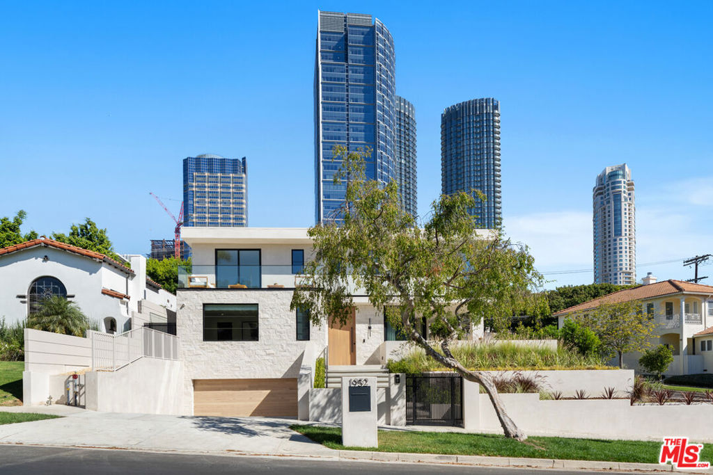 This stunning brand new Century City Adjacent 5 bedroom/5.5 bath Contemporary property offers modern luxury with impeccable high-end designer finishes throughout and boasts openness and expansive views of the Century City skyline. This gated property is set back on a knoll with stunning curb appeal including exterior stone accent wall and smooth stucco, expansive hardscape with drought-resistant landscaped planters. Designed for seamless indoor-outdoor living, the property features high ceilings, walls of windows and multiple 10-ft stacking sliding doors opening to patios and balconies on all levels that blend the spacious interiors with the surrounding natural beauty. Enter this desired open floor plan into a great room filled with natural light and includes includes custom built-ins, a 60-inch linear fireplace with a stone facade, a wine storage cabinet, and spacious dining area with phenomenal corner stacking sliding doors that open the entire room to outside wrap-around patio. The chef's dream kitchen showcases Dekton honed countertops, rift white oak cabinetry with panel-ready appliances and brass hardware, expansive central island with a breakfast bar and second sink, and stainless steel 6-burner range with a griddle and double ovens. Enjoy backyard views through a window above the sink, overlooking a beautiful Italian stone patio, pool with fountain feature wall, and a built-in outdoor BBQ area with a fridge. The main level includes a bedroom with a walk-in closet and an en-suite bath. Upstairs, a light-filled hallway with three skylights leads to 3 additional bedrooms, including the primary suite. The primary suite features Roman clay plaster-finished walls, a balcony overlooking Century City skyline, two walk-in closets with led custom lighting, a spa-inspired primary bathroom with floating vanity, a soaking tub that include, an onyx stone finished shower. The 2 additional bedrooms upstairs each have en-suite bathrooms and balcony access, including a wraparound balcony with treetop and sunset views. The lower level features a spacious media/home theatre, a glass-enclosed gym/yoga area, a family/game room, and 5th bedroom with an en-suite full bath. There is direct access to 3-car garage. Additional features include full upstairs laundry room with sink and built-ins, custom closets throughout, custom built-ins including LED lighting, bathrooms with Taj Mahal countertops and Italian/Spanish tile finishes, Smart Home System, multi-zone AC/Heat, powder room with custom travertine floating sink. Just a few blocks to Century City Westfield Mall, Beverly Hills, and UCLA. Westwood Charter School. This entertainer's dream home will take your breath away.