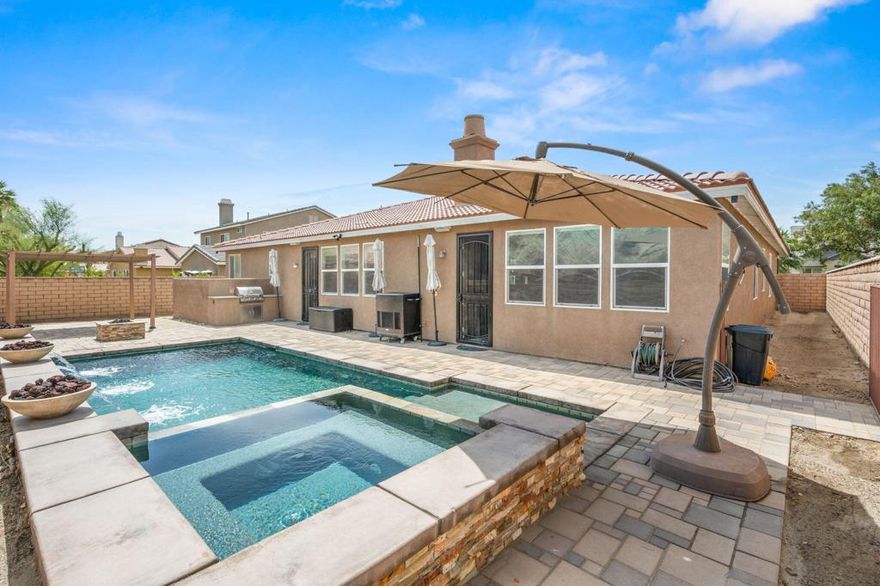 Desert Luxury with Modern Flair!Step into this beautifully upgraded 4-bedroom, 3-bathroom home boasting 3,005 sq ft of open and functional living space. From the formal living room to the expansive great room, every corner of this home is designed with style and comfort in mind. Tile flooring flows throughout, offering a sleek and low-maintenance foundation for everyday living.The heart of the home features a chef-inspired kitchen overlooking the great room and built-in bar--ideal for entertaining. A cozy fireplace warms the space on those chilly desert nights, while a custom built-in desk in the hallway provides the perfect work-from-home setup.  Gorgeous crown molding & surround sound are just some of the many features this beauty provides.Retreat to the custom-designed primary suite, complete with two walk-in closets and a spa-like bathroom showcasing a modern soaking tub, oversized walk-in shower, and dual vanities.Step outside to your private oasis: a sparkling pool and spa with custom cascading waterfalls, LED lighting, a built-in barbecue, cozy stone fire pit, and stunning paver patio--an entertainer's dream come true. A spacious 3-car garage completes the package.This home blends modern luxury with desert charm--schedule your private showing today!