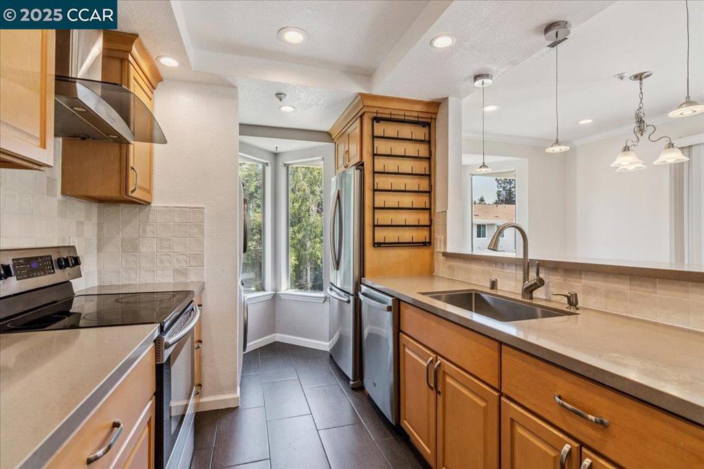 Bright and airy, this upper level end-unit is located in the Carriage Place community of Walnut Creek. This condo has 2 generous sized bedrooms, 1 bathroom, and in-unit laundry...newer Washer and Dryer included! The updated, open kitchen features newer quartz countertops, gleaming backsplash, modern stainless steel appliances and elegant range hood, newer dishwasher, tile flooring and a breakfast bar. The extra kitchen and dining area windows provide loads of natural light. The spacious living room features a wood burning fireplace, beautifully complimented by a modern designer wall. The bedrooms have ample storage with custom closet shelving. The primary bedroom has a walk-in closet. Recently painted, with custom lighting, hardwood floors and crown molding throughout. Enjoy a relaxing moment on the private balcony deck. New water heater installed in 2023. The well-maintained complex offers 2 swimming pools and lush green space. Deeded covered parking space and plenty of visitor parking. Wonderful location near shopping, dining, Sprouts, Starbucks, the Contra Costa Canal hiking trails, Walden Park, and just minutes to downtown Walnut Creek. Ideal for commuters - just a short distance to BART and HWY I680.