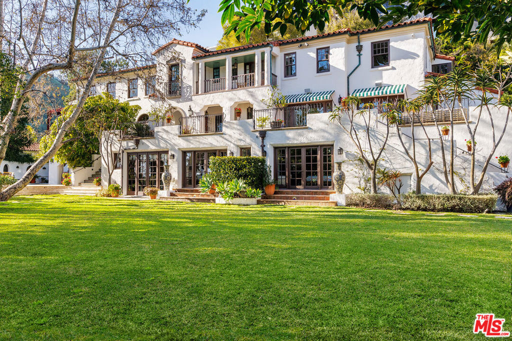 Over the course of its illustrious history, the Blair Estate has maintained its status as one of the most legendary estates in Hollywood. Completely hidden from the street, a long, gated driveway leads to a sprawling 1+ acre park-like haven. Originally built in 1924 by George H. Fruehling for the renowned developer John H. Blair, this masterful estate was crafted to showcase the best of Spanish Mediterranean architecture to a newly developing Los Angeles. Featured in Architectural Digest in 1926, 90 years later on the cover of Anthony Ianacci's book "Hollywood Interiors", and within countless publications in between, the enduring appeal of this timeless estate is undeniable. Extensively remodeled by architect Linda Brettler, who specializes in historic restoration, thoughtful period-appropriate renovations blend seamlessly with the estate's historical details and character. The grand rooms on the main level open up to a magnificent wrap-around patio that merges the indoors with the estate's spectacular grounds. Upstairs, 4 generously proportioned bedrooms include a primary suite with a ~400 sq ft terrace, and offer breathtaking views of the city. Each bathroom boasts custom, hand-made tile work crafted exclusively for the estate, replicating the designs of the 1920s with exquisite attention to detail. Mature trees, a manicured lawn, and meandering pathways are complemented by a pool, grotto, koi pond, and multiple terraces, making this estate a true oasis that feels a world away from its central location in the Hollywood foothills. The lower level of the estate is a veritable playground for entertainment, complete with additional guest bedrooms and bathrooms, a second kitchen, game room, wine room, state-of-the-art theatre, and indoor-outdoor bar and loggia. The estate also features a three-level guest house, currently serving as an expansive office and gym. This is an unparalleled opportunity to own a piece of Hollywood history with scale, privacy, and central location that are rarely seen, and impossible to replicate.