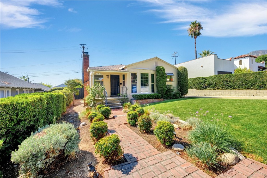 This charming mid-century traditional nestled on a tree-lined street in sought-after North Monrovia, just moments from the newly reopened Canyon Park has great curb appeal. Built in 1947 and cherished by only two owners, this bright and inviting home blends timeless character with thoughtful updates. From the small front porch you enter into a spacious living room with hardwood floors, a classic brick fireplace and abundant natural light. The adjacent dining area features a bay window, while the remodeled kitchen offers ample wood cabinetry, recessed lighting, a garden window, stainless appliances, and stylish tile backsplash. The primary suite is a true retreat with chevron wood floors, built-in entertainment center, a ¾ bath, and French doors leading to the large backyard. A vintage-inspired full bath with original ceramic tile and cast-iron tub serves the secondary bedrooms. Additional highlights include central air & heat, dual-pane windows, ceiling fans, upgraded electrical, laundry hookups, and a 2-car detached garage. Perfectly combining charm, comfort, and convenience, this North Monrovia gem close to nature yet minutes from Old Town, is ready for its next chapter. Image(s) has/have been virtually staged.