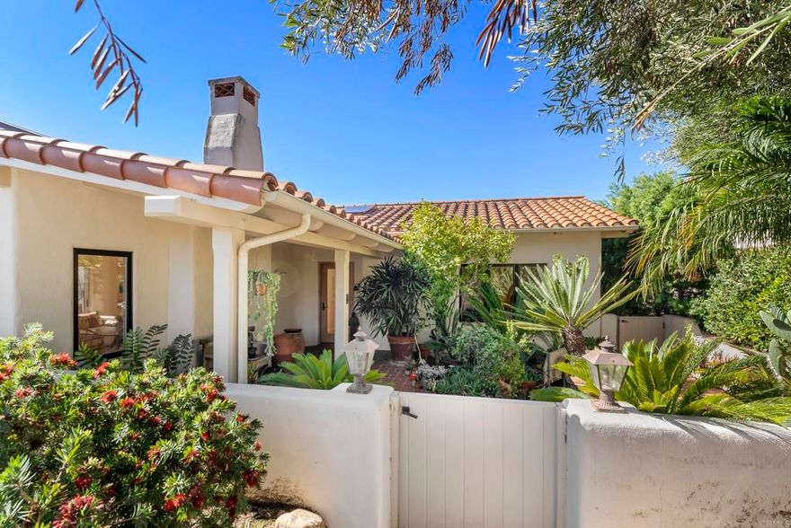 Ideally located in the heart of the Rancho Santa Fe Covenant Village, this single-level residence offers the ultimate blend location, convenience, privacy and serenity. Tucked within the gated Las Cachanillas, an intimate and rare gated enclave of just seven homes, this pristine property lies within a hidden sanctuary—yet is only steps away from the Village Green, The Inn, boutiques, cafés, and the highly acclaimed Roger Rowe School.  With 2 En-Suite bedrooms, a dedicated office and a 2 car attached garage, this single level home lives comfortably and efficiently. Sunlight pours through large windows and glass doors, filling each room with warmth, creating a bright ambiance throughout. The community pool is just steps away, and the property is located in a quiet neighborhood that feels private while still being right in the heart of the village.  The spacious great room flows seamlessly to a large, well landscaped entertainer’s patio, ideal for alfresco dining or relaxing in total privacy. A second patio off the bedroom wing offers a quiet retreat surrounded by lush greenery. The generously sized kitchen and family/dining area also open directly to the outdoors, enhancing indoor-outdoor living year-round, and the dedicated office is ideal for working from home.  This is a rare opportunity to enjoy a lock-and-leave lifestyle in one of the Covenant’s most coveted and convenient locations. Sophisticated, charming, and exceptionally livable—6015 La Flecha is Rancho Santa Fe Village living at its finest.