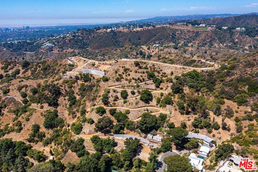 Truly once in a lifetime and one of a kind, this unparalleled property is destined to be the ultimate representation of style and success. This exceedingly private apx. 27.5-acre compound is set on its own promontory just above Beverly Hills. Views are unmatched, extending to the Pacific Ocean and spanning majestic hills, rugged canyons and millions of lights in the city below. A long, gated and elevated driveway accesses the property, which, when complete, will harmonize with the natural setting and erase lines between indoor and outdoor living spaces. There is the potential for two homes to be built encompassing apx. 25,000 square feet each. This will be one of the top show-places every built. Literally above it all, the property is remarkably convenient to the finest dining and shopping that the city has to offer!