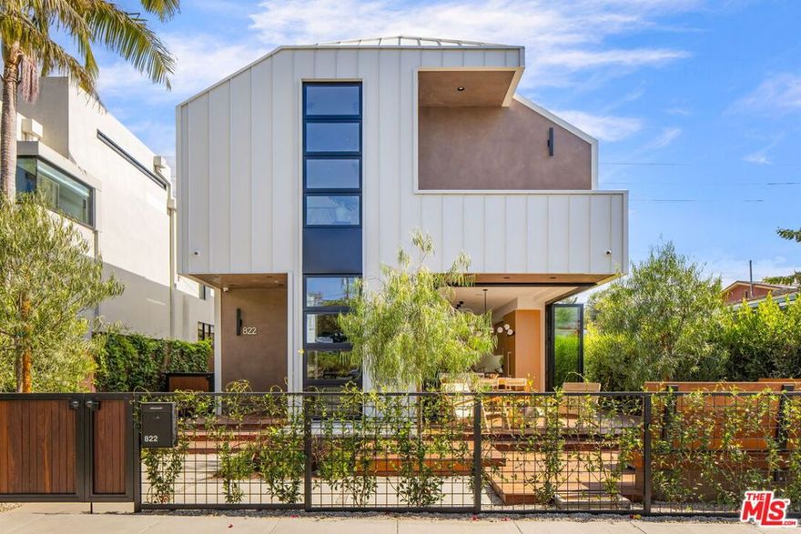 Just blocks from Abbot Kinney and moments from the beach, 822 Superba Avenue redefines modern Venice living where refined design meets the effortless rhythm of coastal life. Expertly developed by GreveBuilt with Hamilton Architects, this new construction residence embodies the precision and warmth of contemporary architecture, combining exquisite materials, thoughtful light, and seamless indoor-outdoor flow. Anchored by broad expanses of glass and skylit volumes, the home is bathed in natural light throughout the day, creating an atmosphere that feels both elevated and intimately livable. The main level unfolds in an open plan living, dining, and kitchen spaces unified by French rift white oak floors and framed by sliding walls of glass that open to an inviting outdoor landscaped lounge. The kitchen is a chef's composition of form and function, fully equipped with a Viking appliance suite and artful white oak slat board custom cabinetry and millwork. Upstairs, the spacious primary suite is a private retreat aerie--its bed wall detailed in Garrison Parallels acoustic oak slats, adding warmth and acoustic tranquility. The spa inspired bath showcases Italian Calacatta marble, sculptural fixtures, and bountiful natural light. Additional upstairs sun-drenched office alcove, bedrooms and bath offer bespoke finishes throughout. The lower level extends the home's versatility, featuring a media and game room alongside a gym that doubles as a secure space with steel-wrapped walls and a double-sided steel single-entry door. The residence also integrates a comprehensive security system with eight cameras and full Lutron home automation for effortless control of light, climate, and ambiance. Life at 822 Superba flows easily between home and the leafy neighborhood beyond. Just a short bike ride to the sand and minutes from designer shopping and renowned dining along vibrant Abbot Kinney, this address offers the ideal blend of architectural tranquility and urban coastal energy. A rare opportunity to own a masterfully crafted modern home in one of Venice's most coveted neighborhoods where design, comfort, and location converge in perfect balance.