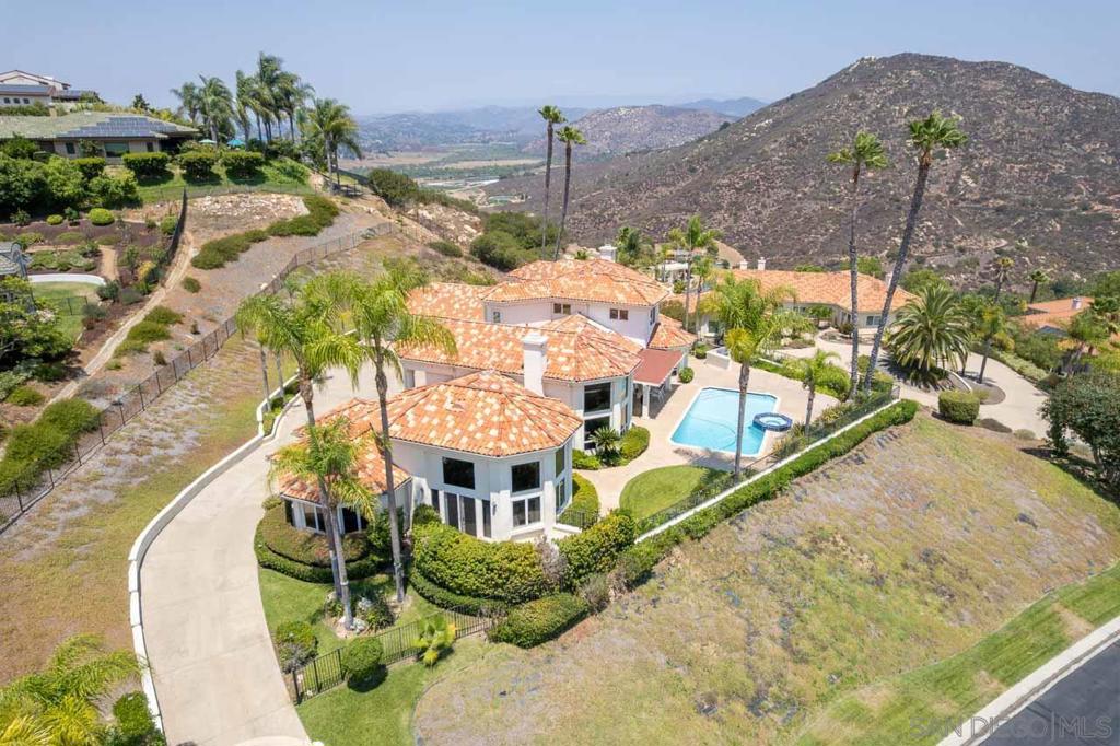Located in the exclusive Highlands Ranch gated community in Poway, this timeless Mediterranean estate offers luxury living at its finest with breathtaking mountain views throughout, pool, spa, patio, BBQ island, fruit trees, and a curved and long driveway providing complete privacy, approximately 1-acre. This rare property blends elegance, privacy, and stylist living in one of Poway’s most sought-after neighborhoods. Walking distance to Bernardo Winery, restaurant, shops and Farmer's Market. The home is adorned with French doors, five well-appointed bedrooms, and a paneled library, custom built-ins bookcases, cabinets and furniture adjoining the master bedroom, with accent lighting, elegantly recessed ceilings, and polished marble entry floor. Enjoy the view of the surrounding mountains and the pool from the connected formal living room and dining room, panoramic mountain view from the spacious family room and every other bedroom. Relax in the master bath tub and steam shower, and feel luxurious in an impressive floor to ceiling custom designed modern walk-in closet.