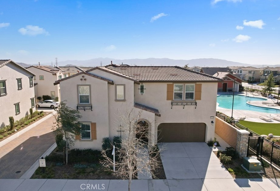 Welcome to this beautifully maintained 4-bedroom, 3-bathroom home in the highly sought-after Grand Park community of Ontario Ranch. Built in 2018, this modern residence features a spacious and functional open-concept layout, ideal for various lifestyles. Durable SPC flooring flows throughout most areas, complemented by elegant plantation shutters, combining both style and comfort.The main level offers a versatile bedroom and full bathroom, perfect for guests or adaptable to your unique needs. A chef-inspired kitchen seamlessly connects with the dining and living areas, creating an inviting atmosphere for entertaining and everyday enjoyment. Upstairs, a spacious loft provides excellent potential as a home office, playroom, or media area. Additionally, you'll find three bedrooms, including a well-appointed primary suite complete with a walk-in closet and dual-sink bathroom. An upstairs laundry room and conveniently located linen closet enhance functionality. Step outside to the serene backyard, which boasts a newly added pergola—ideal for relaxation or hosting gatherings with family and friends. Further elevating the home's appeal, there is a Tesla EV charging station, and leased solar panels provide energy efficiency at a very low cost. The property also benefits from a low HOA. Residents of Grand Park community enjoy premium amenities such as a pool, spa, water play area, playground, and clubhouse. Perfectly situated near schools, parks, shopping centers, and with easy access to the 15 and 60 freeways, this exceptional home offers the perfect balance of comfort, convenience, and modern living. Don’t miss your opportunity to make this wonderful property your new home!