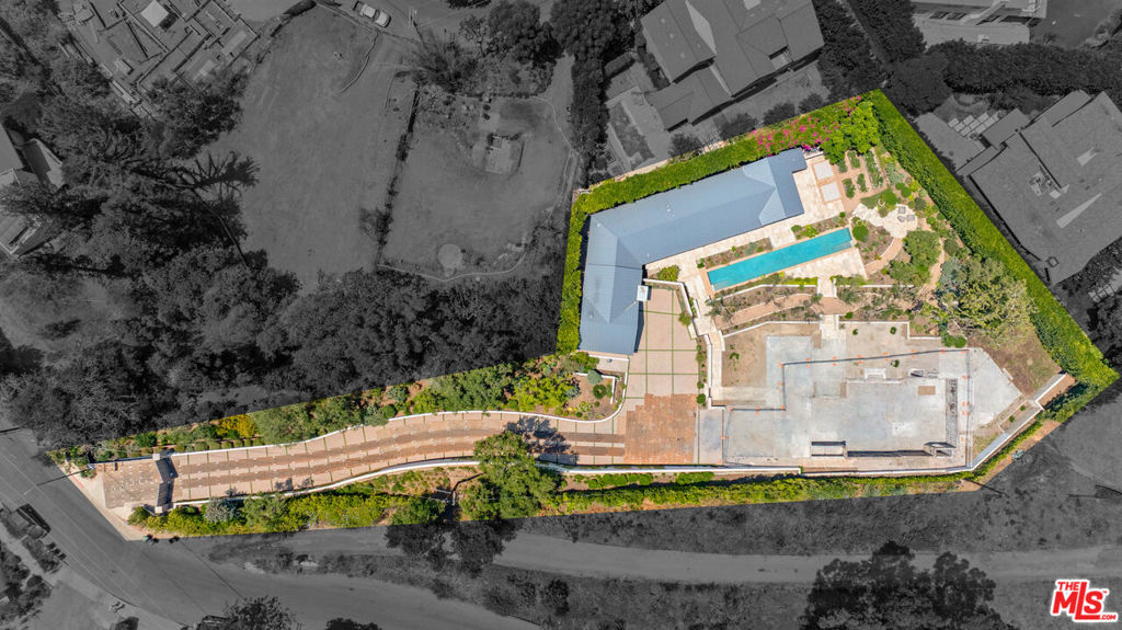 Set behind reclaimed oak gates on a rare acre of ultra-private grounds, this remarkable Pacific Palisades offering presents an extraordinary opportunity to build a dream-worthy estate just minutes from the coastline. Spanning two adjacent parcels, this secluded compound blends exclusivity, natural beauty, and architectural pedigree -- positioning it as one of the most compelling redevelopment opportunities on the Westside. Prior to the recent wildfire event, the site was home to an ~8,500-square-foot main residence and a ~2,400-square-foot guest house, both completed in 2021 with exquisite detail. While the main residence was lost, the guest house and the majority of the impeccably curated grounds remain intact, offering a meaningful foundation for a legacy estate. Nestled among mature trees and lush landscaping, the standing guest house is a vision of understated luxury. Rustic charm meets modern refinement with vaulted, beam-lined ceilings, a stone-clad fireplace, and sunlit living spaces that open to the surrounding gardens and terraces. The gourmet kitchen is impeccably outfitted with top-tier Viking appliances, built-in wine storage, a stone-topped peninsula, and a walk-in pantry -- ideal for entertaining in style. Two gracious en-suite bedrooms are complemented by a powder room, laundry room, infrared sauna, and a 2-car garage with direct access. Thoughtful finishes, organic textures, and seamless indoor-outdoor transitions speak to a design philosophy centered on comfort, wellness, and timeless quality. The lush, park-like grounds are a marvel in their own right. At the heart of the estate lies a 70-foot ozone lap pool, spa, and cold plunge -- designed for both relaxation and revitalization. A covered outdoor kitchen and dining pavilion is ideal for entertaining year-round, while raised gardens and a grove of 50+ year-old olive trees imported from Napa offer peace, privacy, and pastoral charm. Included in the sale: Architectural plans for the former main residence, landscape and hardscape design plans, final debris removal certificate, and debris assessment and sampling reports. Whether you envision recreating the estate's former grandeur or designing something entirely new, this offering provides an invaluable head start -- saving time, energy, and hurdles for the next owner. Few properties in Pacific Palisades combine this level of privacy, scale, architectural value, and coastal proximity. This is more than a development site -- it's a canvas for legacy creation in one of the Westside's most coveted enclaves.