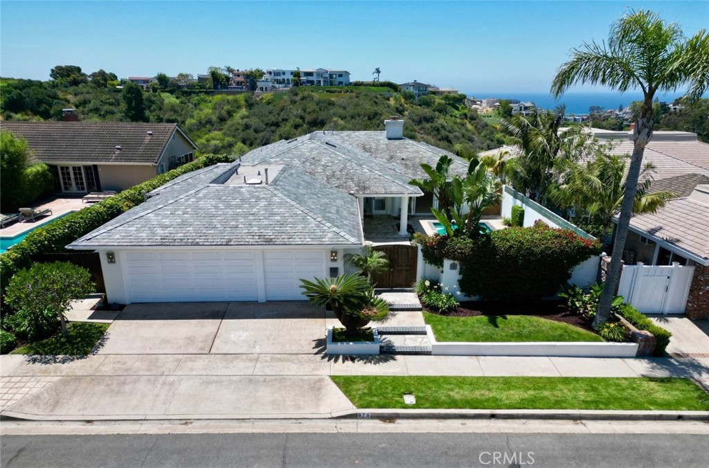 Set on a generous 7,920-square-foot lot, this single-level residence offers 4 bedrooms, 3 bathrooms, plus a dedicated office, with approximately 2,900 square feet of thoughtfully designed living space. The open light-filled floor plan is designed for seamless indoor-outdoor living, highlighted by skylights, expansive windows, and effortless access to multiple outdoor areas. A gated courtyard welcomes you with a private pool surrounded by lush, tropical landscaping, while the serene backyard offers panoramic ocean and golf course views—perfect for sunset gatherings and quiet relaxation. Inside, the chef’s kitchen is equipped with a center island, custom cabinetry, and a charming breakfast nook with built-in banquette seating, all oriented to capture the stunning views beyond. The living and dining areas flow gracefully to the outdoors, creating an ideal setting for entertaining or simply enjoying the beauty of coastal California. The spacious bedrooms provide comfort and privacy, while the office offers flexibility for remote work or creative pursuits. Located moments from the vibrant Corona del Mar Village, pristine beaches, world-class dining, boutique shopping, and the renowned Pelican Hill Resort, this home also offers proximity to top-rated schools and Fashion Island. A rare opportunity to own a front-row, single-level residence showcasing breathtaking, unobstructed views of the Pacific Ocean, Catalina Island, and the prestigious Pelican Hill Golf Course—luxurious coastal living at its finest in the heart of Corona del Mar.