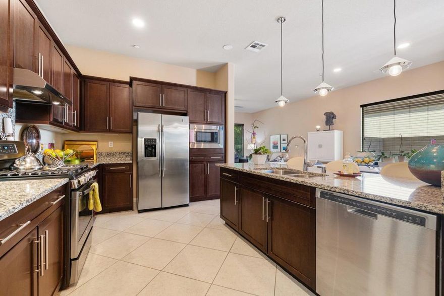 IMPROVED PRICE**SUN CITY SHADOW HILLS - active adult community. Beautiful open floor plan with slab granite counters, espresso colored wood cabinets, and stainless steel appliances. Gas stove, tile on the diagonal with carpeted bedrooms, sliders in primary bedroom and living room. Large primary bedroom with large shower w/seat and dual sinks. Second bedroom. is app. 10' wide X 11' long and has its own bathroom with tub/shower. Large laundry room with cupboards. And, to top it off is a lushly treed back yard with a very large extended patio cover, excellent for relaxing or entertaining. 6-7 fruit trees. New fans, low voltage ceiling lighting, new garage door and new outdoor landscape lighting. Pathway to Club House and pool 10 minutes away. Don't miss this opportunity at a great house at a great price! WELCOME TO YOUR NEW HOME!