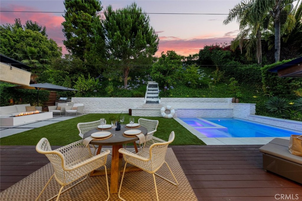 Contemporary elegance and refined craftsmanship come together in this exceptional Rancho Palos Verdes residence. Situated on a flat lot just moments from top-rated, nationally recognized schools, this home was reimagined from the ground up in 2017 by acclaimed French architect J. Thibault. The result is a thoughtfully curated living experience defined by sophistication, comfort and quality. Spanning over 3,200 square feet, the home offers 6 bedrooms and 5 bathrooms, including a convenient Jack-and-Jill setup. The main level is anchored by a bright and open layout, where the living and dining spaces flow seamlessly into a sleek kitchen outfitted with Thermador appliances, Italian cabinetry and striking waterfall-edge countertops. Designer tile sourced from Spain and Italy, paired with warm European finishes, elevate the interiors with a distinct sense of luxury. Fleetwood sliding doors lead to an expansive and private backyard oasis—a sun-soaked retreat designed for both relaxation and entertaining. At the heart of the outdoor space is a stunning pool, surrounded by lush landscaping, a tranquil water feature and a built-in grilling area perfect for weekend gatherings. As day turns to night, multiple fire pits and thoughtfully placed LED lighting transform the space into a captivating outdoor lounge. Inside, ambient LED lighting continues throughout the home, while downstairs, an additional entertainment area with a full bar offers the ideal spot for casual evenings in. Upon its meticulous remodel, the home was certified toxin-free, ensuring peace of mind and modern healthy living. This home offers a lifestyle designed for those who appreciate clean lines, inspired design and effortless California living.
