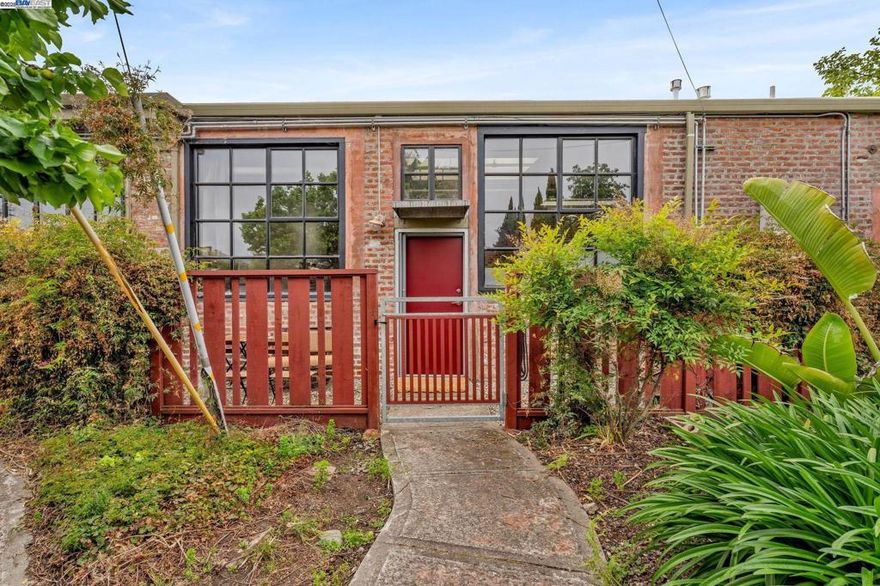 Welcome to this one-of-a-kind brick loft condo in Fruitvale, Oakland, offering a unique blend of urban living and tons of amenities.   Full of natural light, this 2 bedrooms, 1 bath, 1,232 square feet of open floor plan living space have soaring ceilings, skylights and oversized large windows.  The huge kitchen has so much counter space for cooking and entertaining.  And there is an in-unit  laundry closet with extra storage space.    This is an end unit with lots of privacy, with two parking spaces and an additional storage shed.  There is also a gated front yard, perfect for pets,  gardening and patio furniture.  The community is completely gated, with a large green outdoor area for all residents.