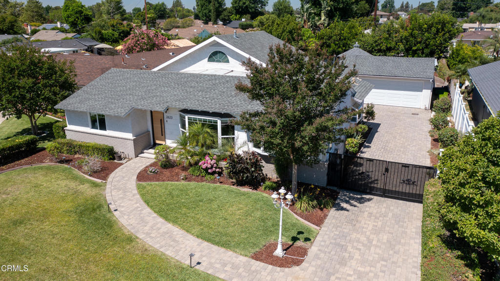 This beautifully upgraded home, featuring a gourmet kitchen, a resort-style backyard & designer touches throughout, is beckoning. Located on a beautifully landscaped lot with a lush green lawn & a paver walkway leading to a custom front door, this meticulously maintained home offers the perfect blend of classic charm & modern upgrades. Inside, sunlight streams through expansive front picture windows, illuminating hardwood floors & highlighting the home's warm & welcoming character. The formal living room is a showstoppera'bathed in natural light, it features recessed lighting, crown molding & a newer gas fireplace with an electric start & an updated chimney. The picture windows showcase the beautifully landscaped front yard, creating a sense of spaciousness & serenity throughout the day. The formal dining room offers its own large bay window, chair rail molding & elegant ambiance, ideal for intimate dinners or festive gatherings. The chef's kitchen is truly a standout with quartz countertops, tile flooring & a full suite of high-end appliances: a Miele gas cooktop with built-in deep fryer & range hood, Bosch built-in espresso maker, dishwasher, double-oven with warming drawer, under-counter microwave & a stainless steel dual sink beneath another sunny bay window. A large kitchen island provides counter seating next to a side-by-side laundry space. The kitchen opens to the spacious family room, with French doors leading to an entertainer's dream backyard. The pergola-covered patio includes space for an outdoor TV, while a gated pool area, a water feature with a babbling brook & a grassy lawn with mature apple & guava trees provide peaceful & private enjoyment. The expansive primary suite features a walk-in closet with built-in shelving & a spa-like ensuite with a dual-sink vanity, jetted soaking tub & oversized shower with dual showerheadsa'including a rain shower. 2 additional bedrooms, both well-sized with ceiling fans & ample closets, share a hallway bathroom with a separate tiled tub & shower & a floating single-sink vanity. Additional amenities include a finished detached two-car garage with epoxy flooring & built-in storage, a custom paver driveway wired for EV charging, a whole-house natural gas Generac generator, surveillance cameras & a home security system. This home truly delivers space, luxury & function in one of the area's most desirable neighborhoods. This home is ready for its new owners to experience modern living & effortless entertaini